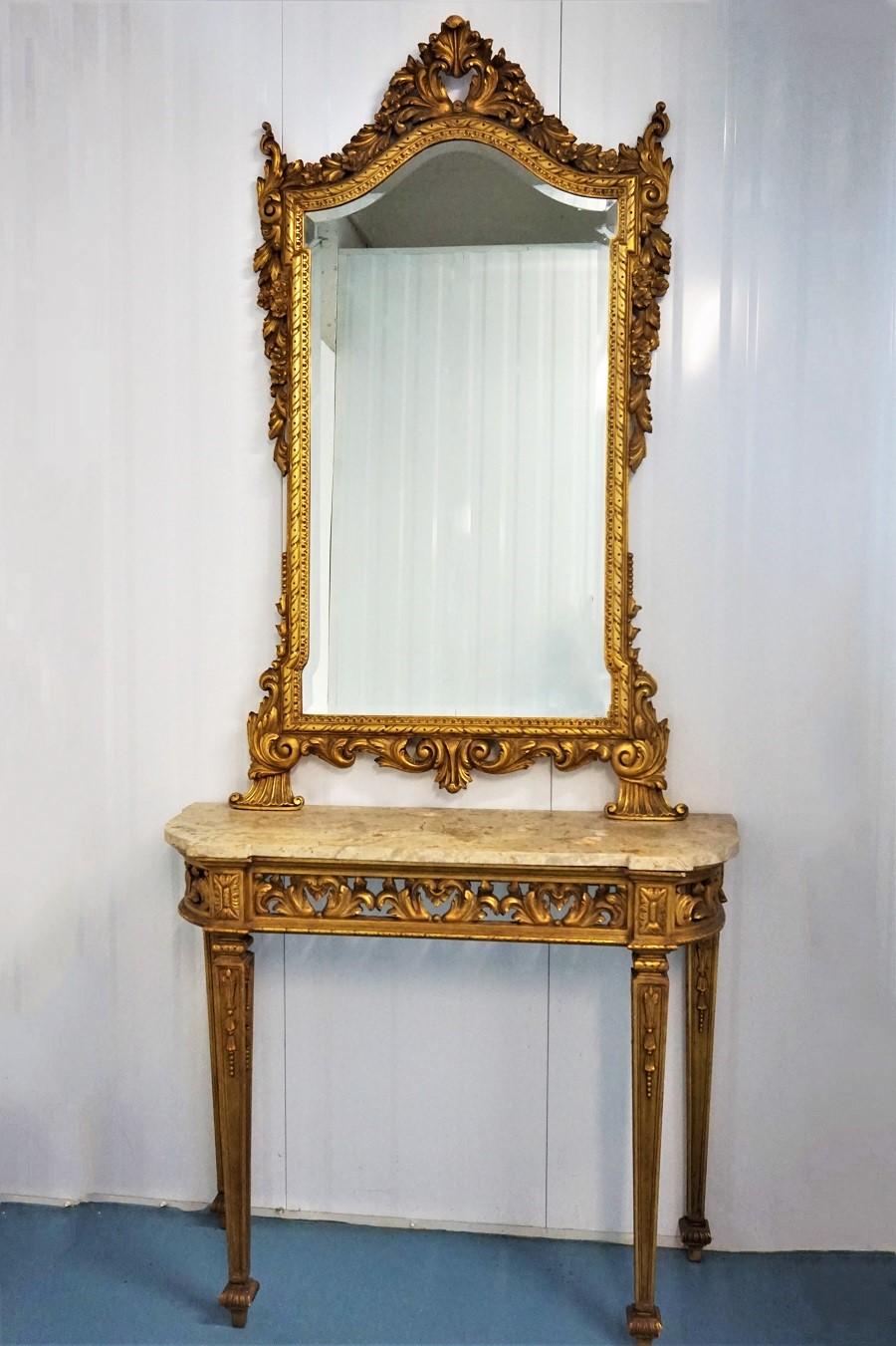 Console et miroir en bois doré de style Louis XVI de la fin du XIXe siècle. La table est finement sculptée à la main dans des détails précis sur quatre pieds fuselés et cannelés avec d'élégantes sculptures feuillagées. Au-dessus de chaque pied, des