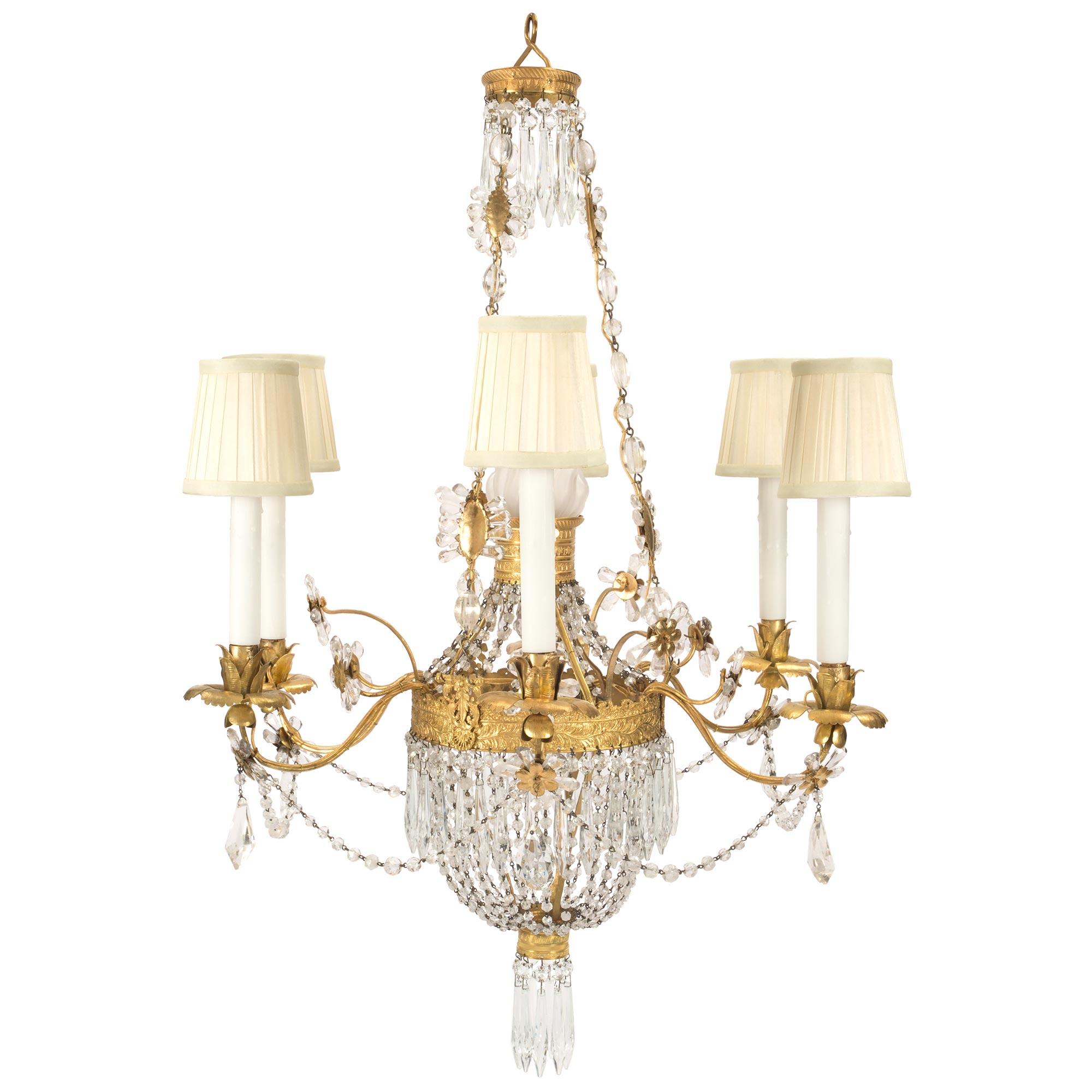 A stunning and very unique Italian early 19th century Louis XVI style rock crystal and gilt metal chandelier. At the bottom is a gilt metal finely chased base with hanging pendants. Crystal garlands join to the central gilt metal support with