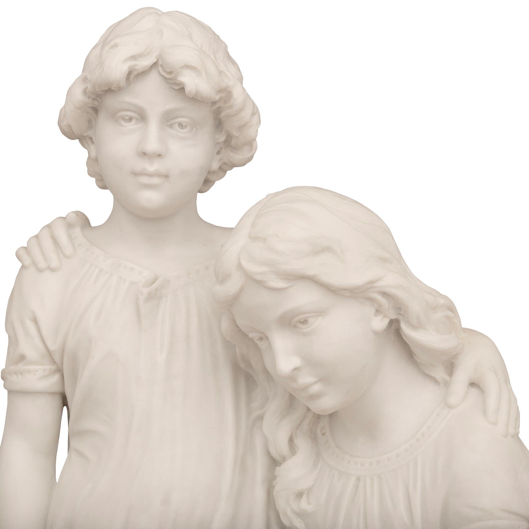 A charming Italian 19th century white Carrara marble statue of a brother and sister at the seashore. The sister is seated on a rock while dressed in a long dress and holding a large seashell on her lap. The standing brother is looking ahead while