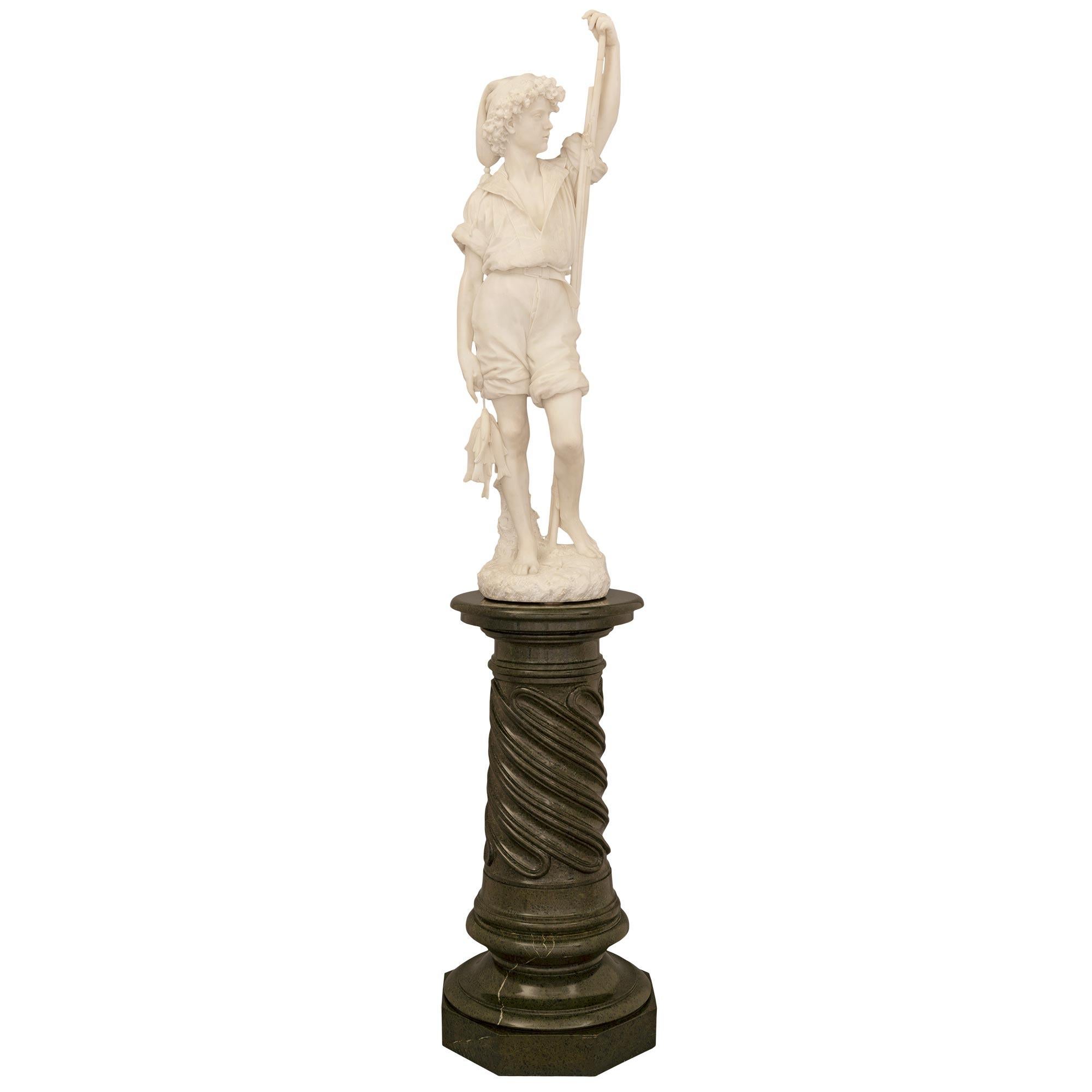 A stunning and extremely high quality Italian 19th century white Carrara marble statue of a Neapolitan fisher boy on a Vert de Patricia marble pedestal. The statue is raised on a most handsome Vert de Patricia marble pedestal with a fine octagonal