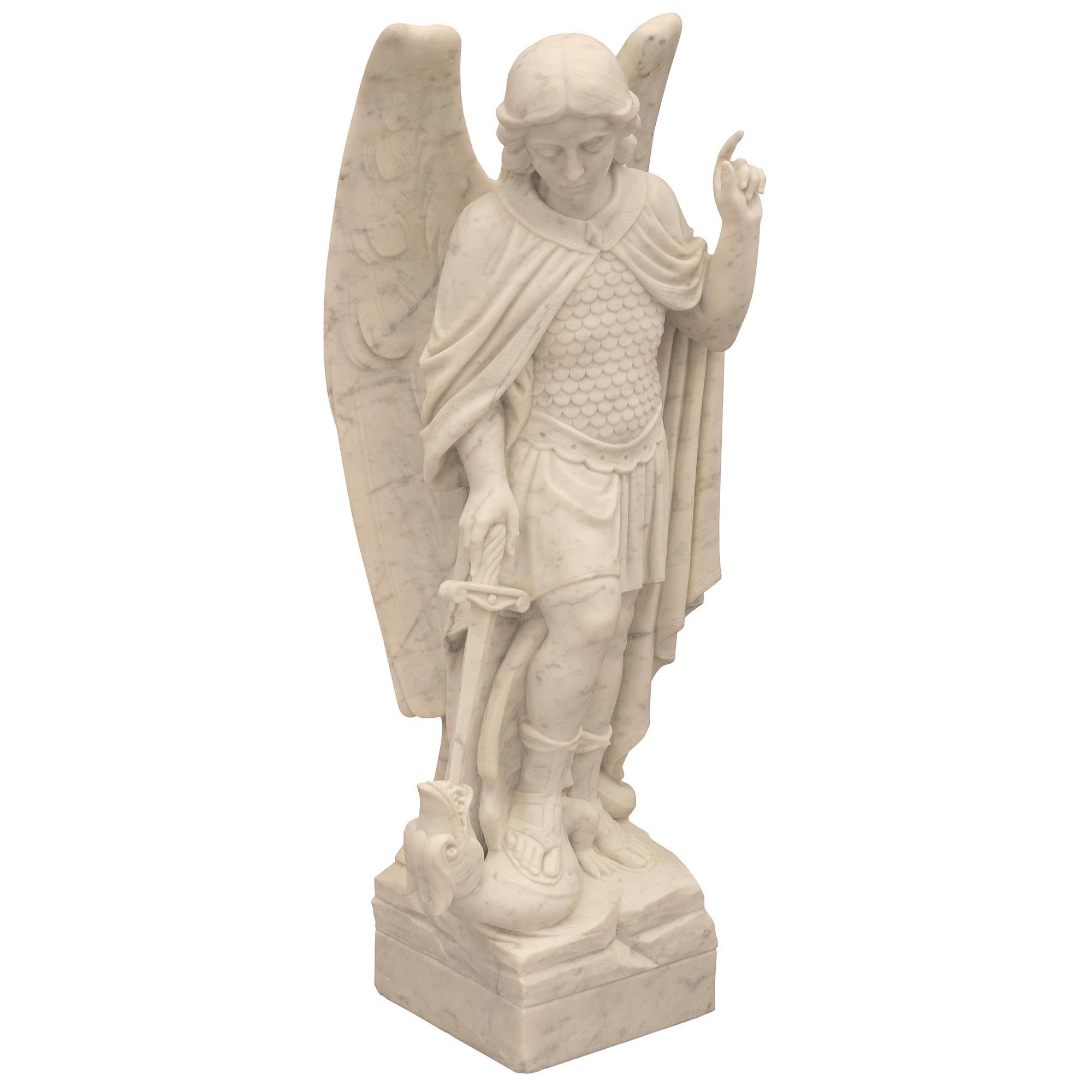 A stunning and very high quality Italian 19th century white Carrara marble statue of Saint Michael slaying the dragon. The statue is raised by a square base with a fine ground like design. Above is the striking and wonderfully executed Saint Michael