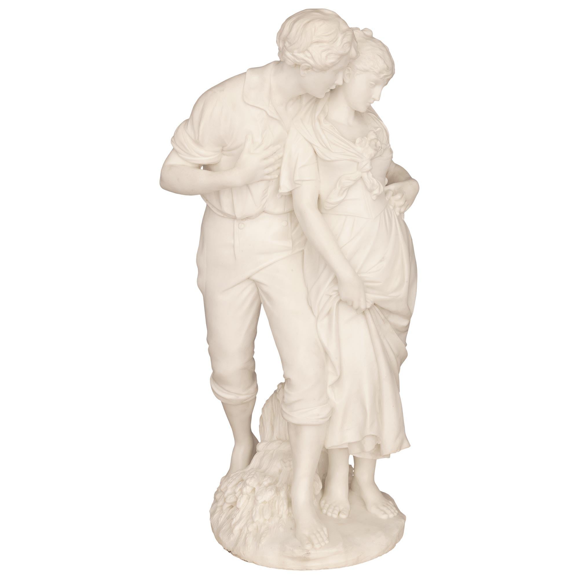 A stunning and most charming Italian 19th century white Carrara marble statue of young courtship. The romantic statue is raised by a circular base with a fine ground design where the lovers are standing with a sheaf at their feet. The beautiful