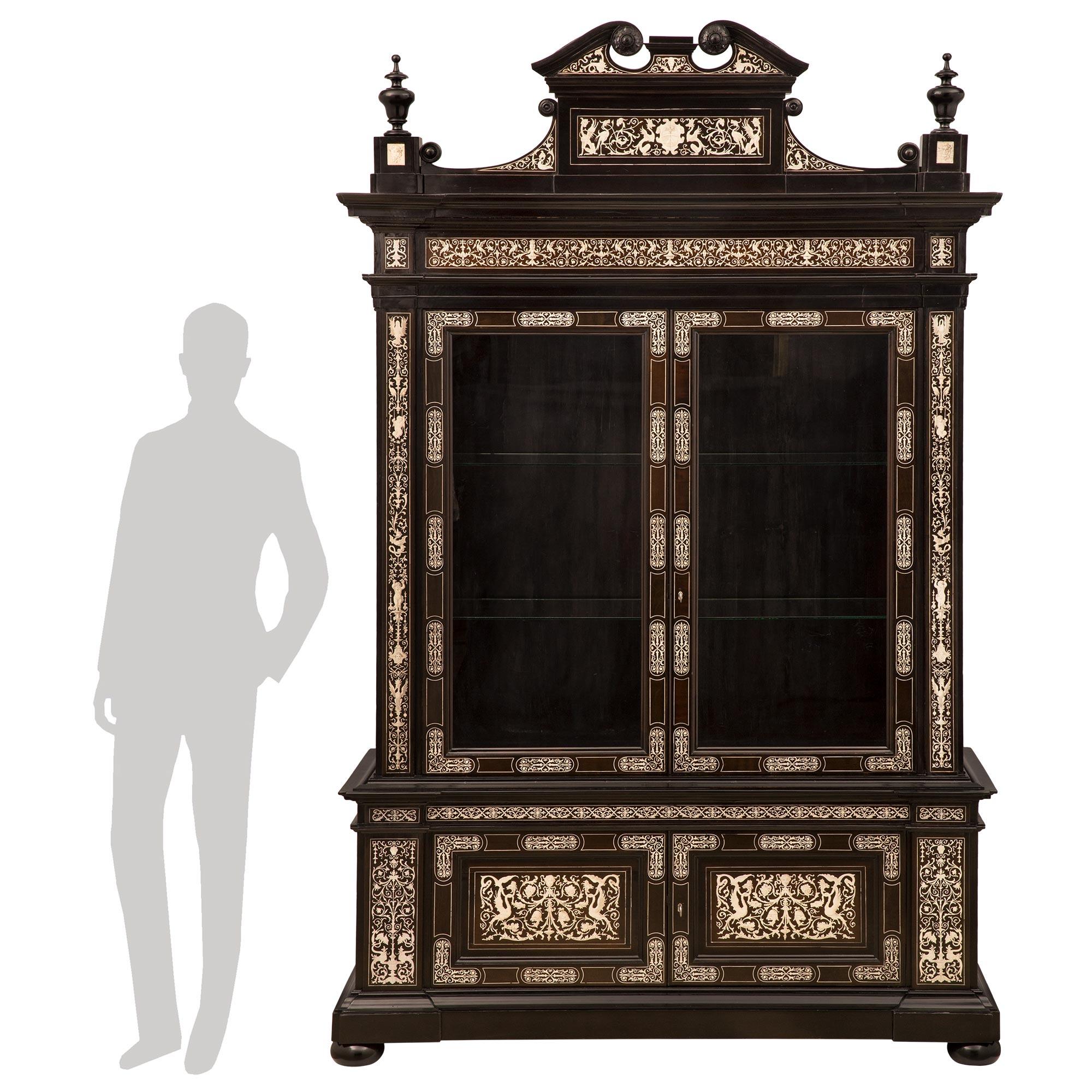 A stunning and large scale Italian 19th century Milanese st. ebony and bone cabinet vitrine. The impressive four door vitrine is raised by fine bun feet below the straight frieze with an elegant mottled band. The base displays two doors decorated