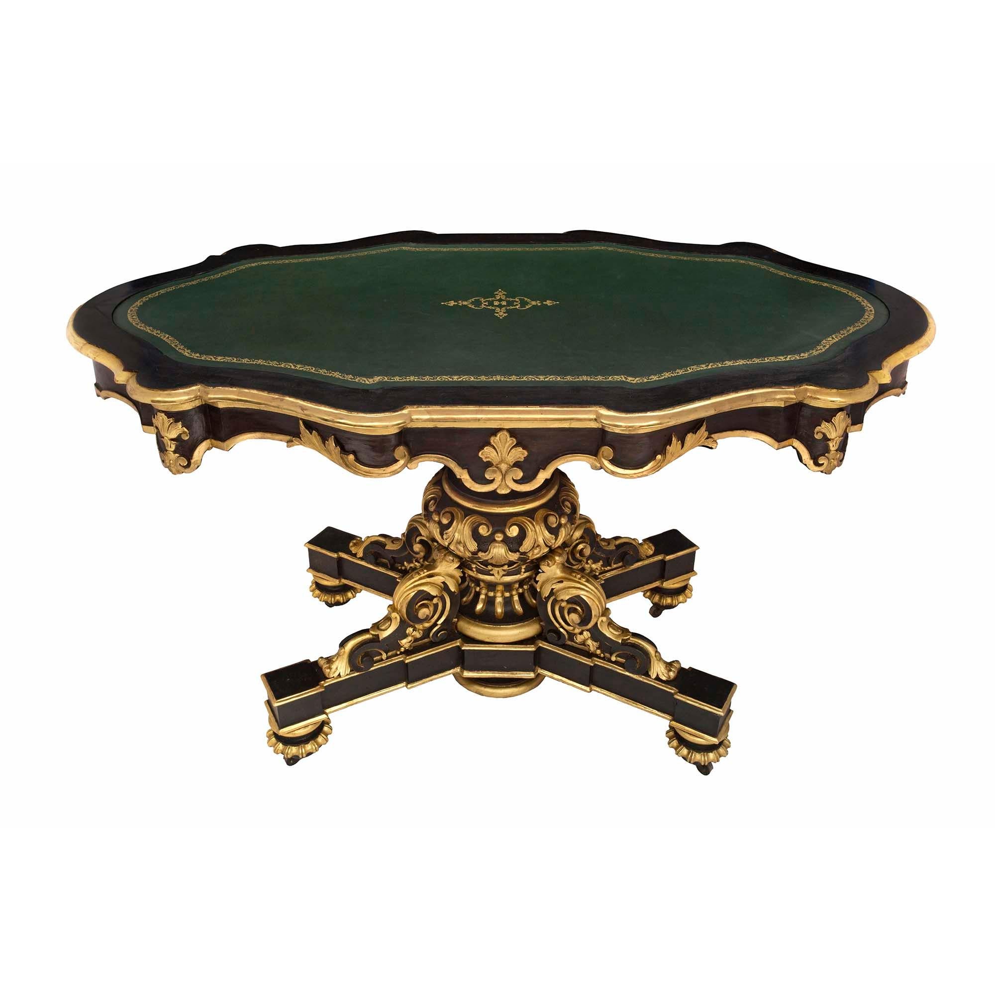 A most impressive Italian 19th century Napoleon III period patinated black and giltwood oval center table. The table is raised by circular mottled feet with a decorative reeded giltwood band and their original casters. The X-shaped base displays a