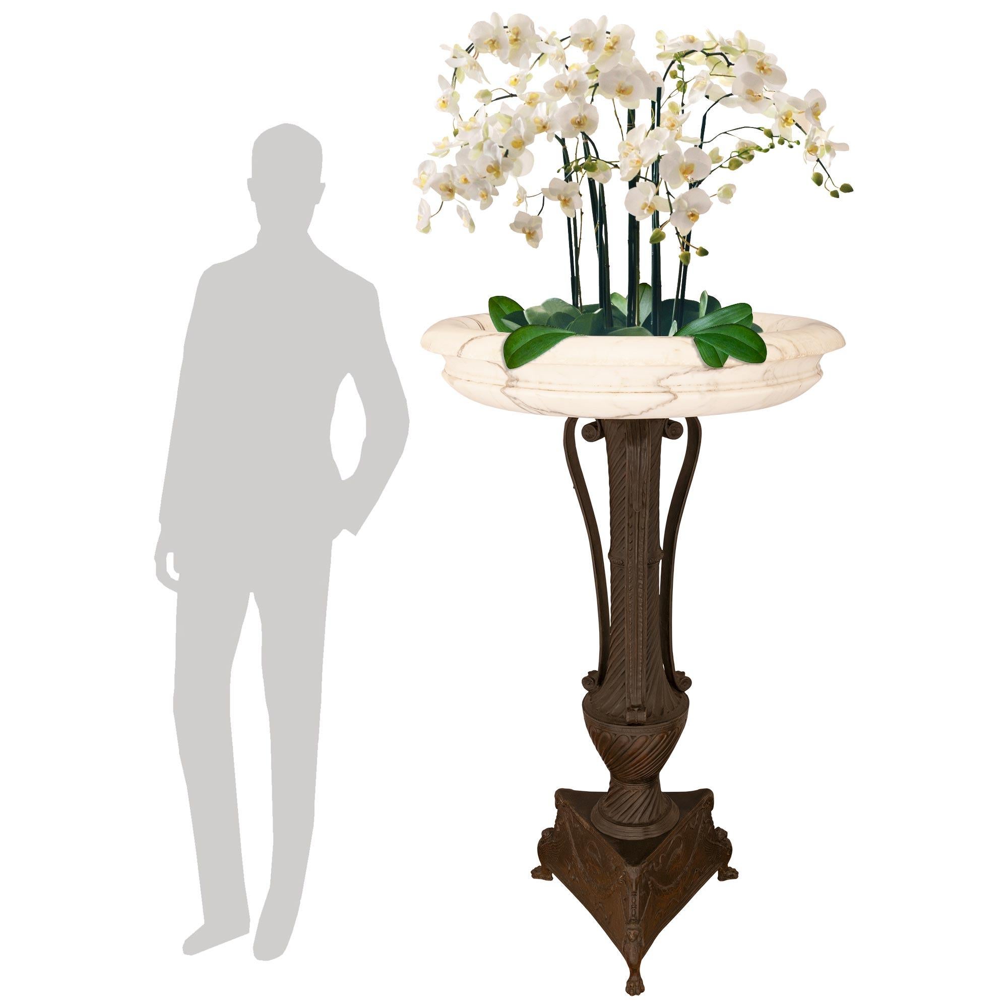A most attractive Italian early 19th century Neo-Classical st. patinated Bronze and white Carrara marble birdbath/planter. This elegant birdbath is raised on a patinated Bronze base supported on three oversized lion's paw feet leading to handsome
