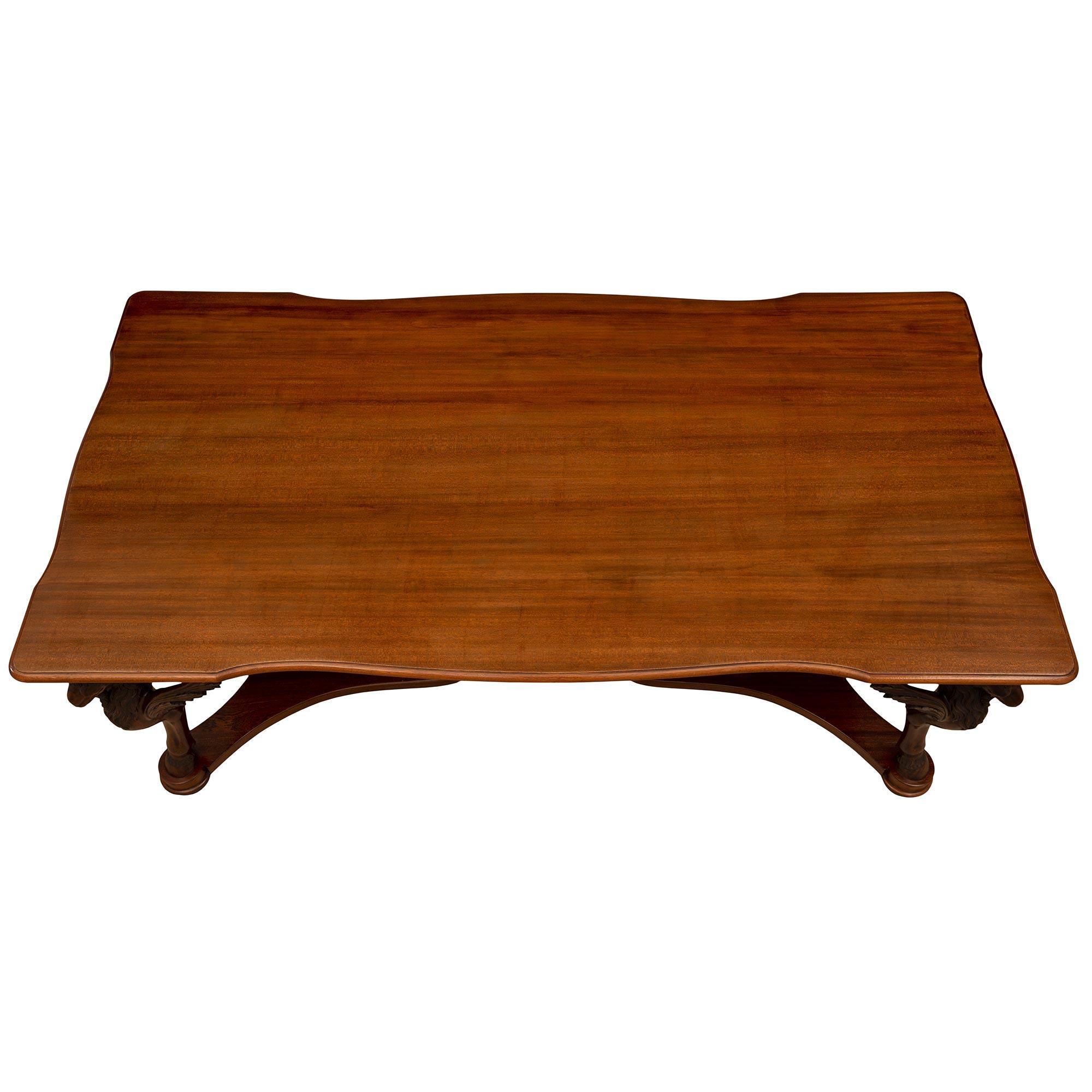 A handsome and most impressive Italian 19th century Neo-Classical st. Mahogany center table. The rectangular table is raised by elegant mottled bun feet below stunning supports in the shape of rams legs with hoof feet and richly carved open winged