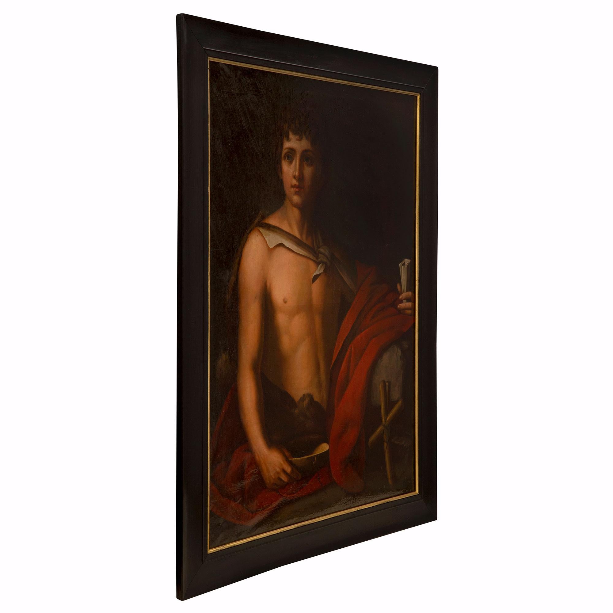 A fine Italian 19th century neo-classical st. oil on canvas painting of a young man. The young man has his red cloak draped over his left arm while holding a scroll in his left hand. He holds a bowl by his side with a cross in the foreground. Framed