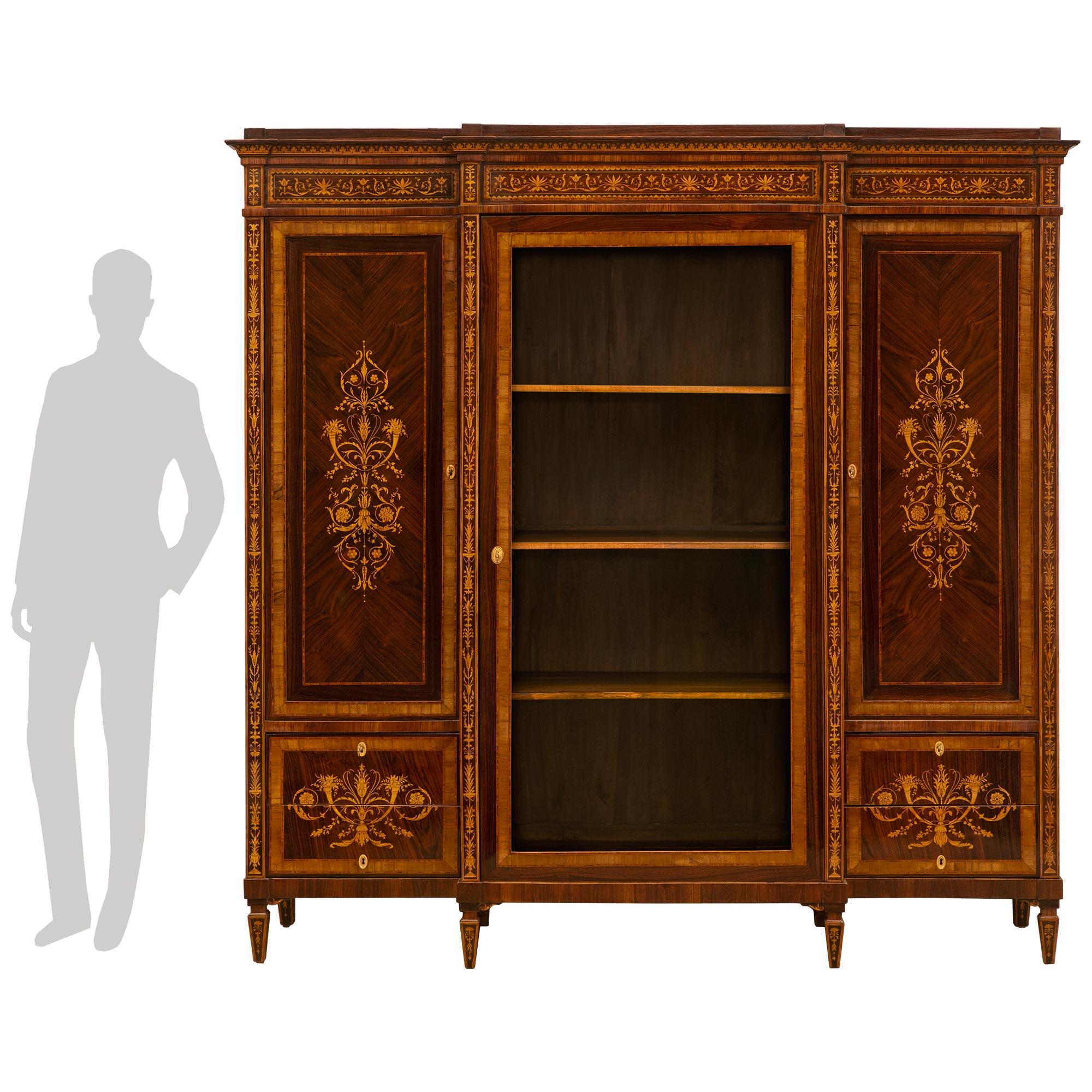 An impressive Italian 19th century Neo-Classical st. walnut cabinet vitrine in the manner of Maggiolini. The cabinet is raised on eight square tappered supports with elegant maple wood inlays. Above the straight frieze at each side are striking