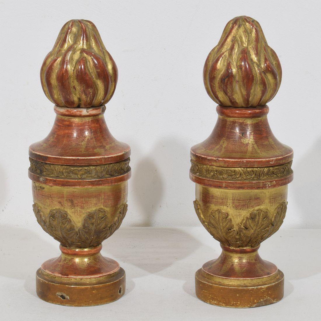 Precioso par de adornos de madera con restos de su dorado original. Italia, hacia 1800-1850.
Desgaste y pequeñas pérdidas.
H:29 cm  Anch:11cm Prof:11cm 
