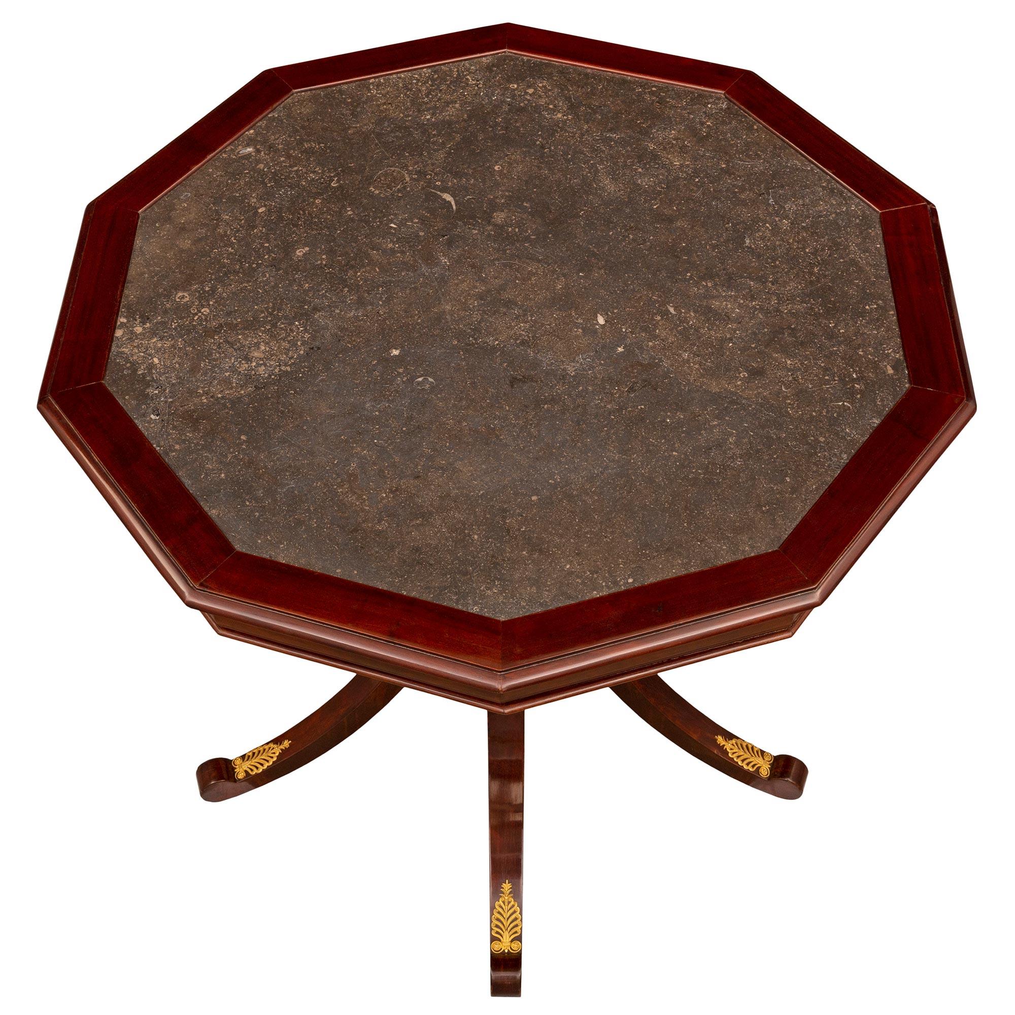 An impressive Italian 19th century Neo-Classical st. Mahogany, ormolu, and fossilized black marble center table. The table is raised by five elegantly curved legs adorned with beautiful pierced ormolu palmettes and richly chased acanthus leaves in a