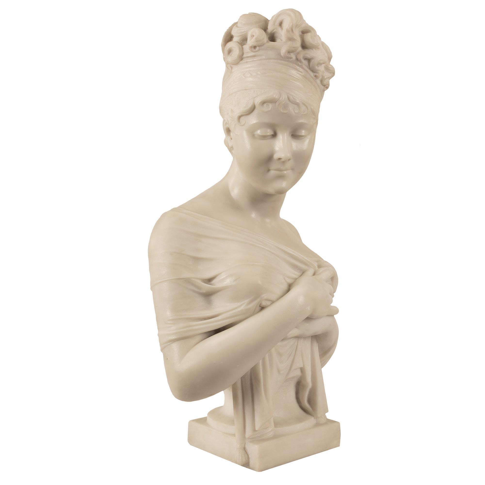 A beautiful and wonderfully executed Italian 19th century Neo-Classical st. white Carrara marble bust of young Madame Juliette Recamier. The bust is raised by a square base below the charming and extremely elegant Juliette. She is holding up her