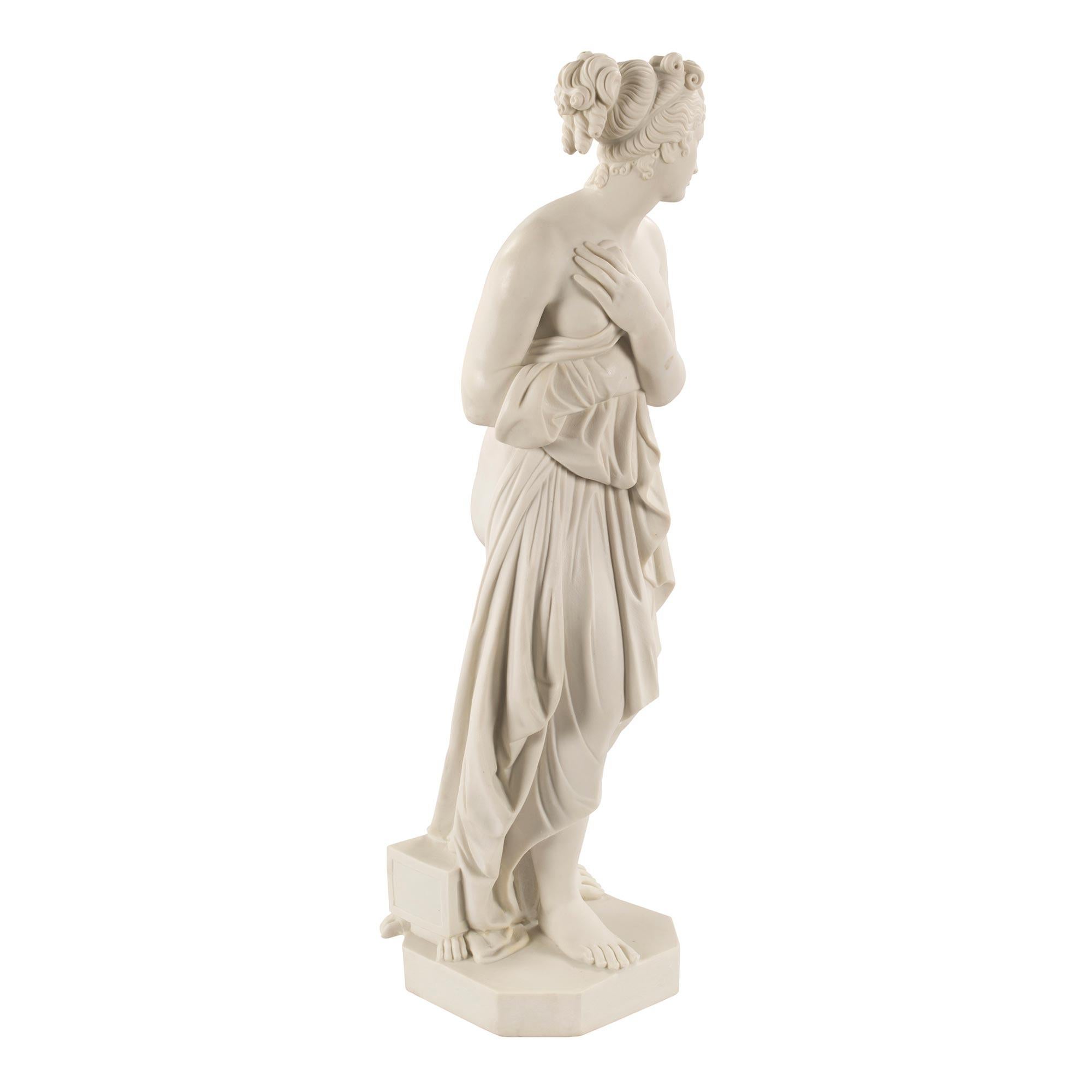 A beautiful Italian 19th century neoclassical style Biscuit de Sèvres statue of Venus. The masterfully sculpted statue is raised by a square base with cut corners. Venus stands with a finely carved box with paw supports at her feet. She is draped in