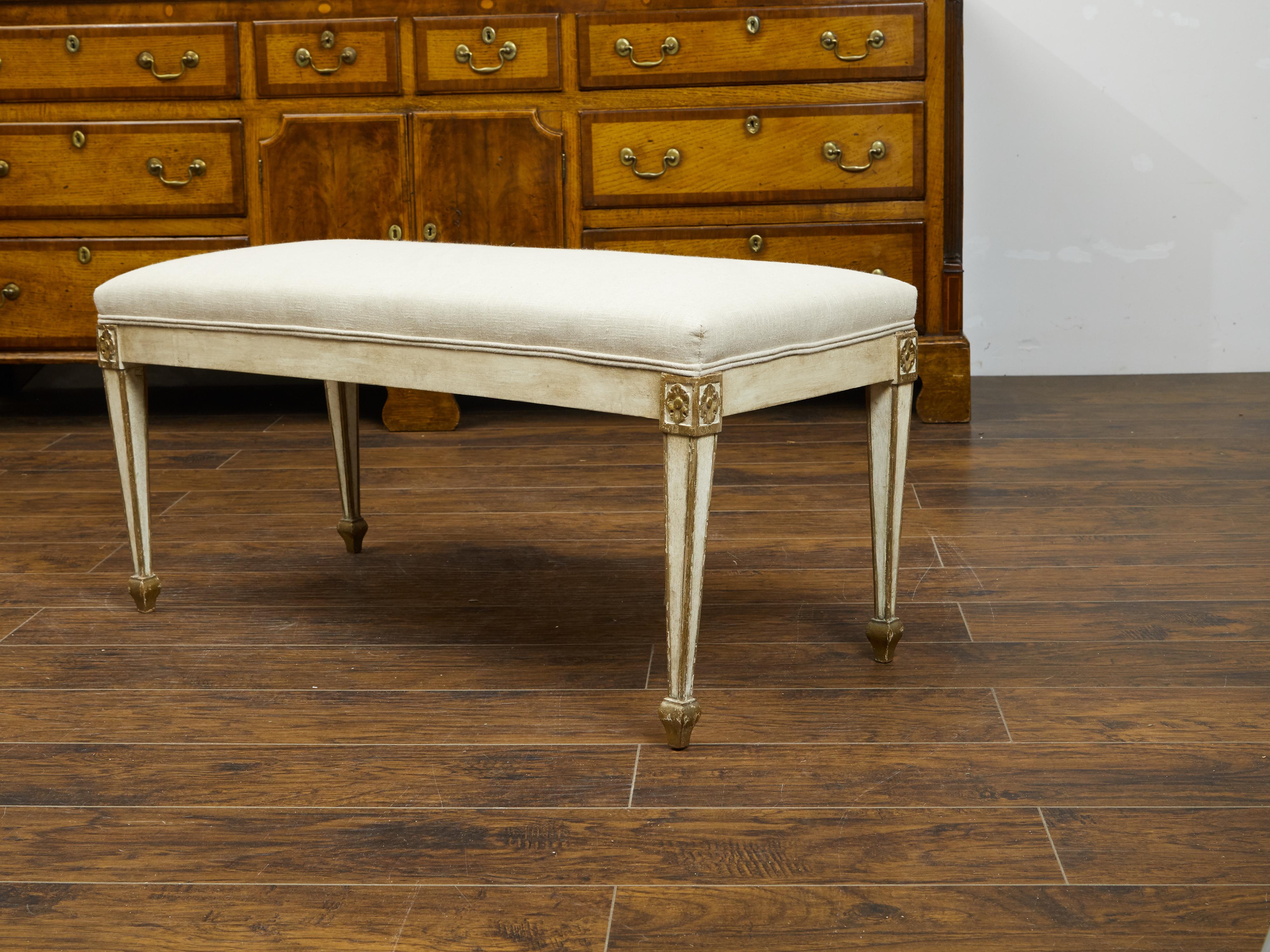 An Italian Neoclassical style painted wood bench from the 19th century, with tapered legs, carved gilded rosettes and new upholstery. We currently have two available, priced and sold $3,995 each. Created in Italy during the 19th century, this