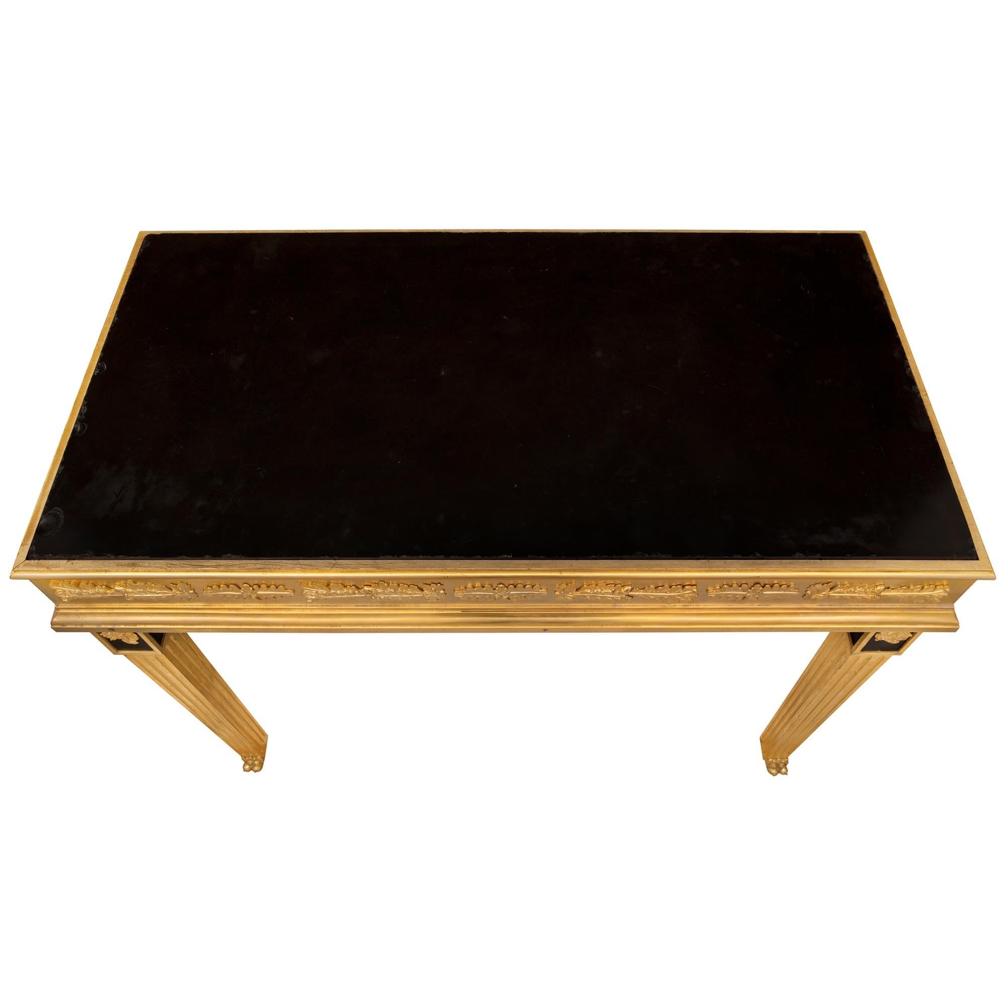 Superbe table de centre néo-classique italienne du 19ème siècle, de très haute qualité, en bronze doré et marbre noir belge. La table de forme rectangulaire est surélevée par de beaux pieds carrés fuselés cannelés avec d'impressionnants pieds pattes