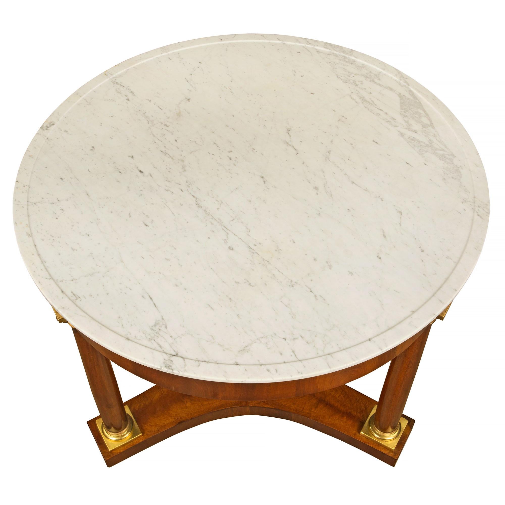 A very handsome Italian 19th century Neo-Classical st. walnut, giltwood and marble circular center table from Luca. The table is raised on three bun feet below the concave sides stretcher. Above are three column supports with a giltwood base and