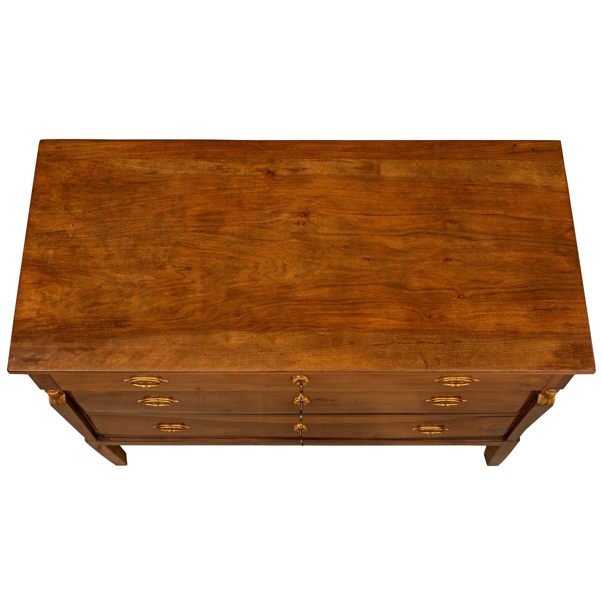 A very handsome Italian 19th century neoclassical St. walnut and ormolu commode. The chest is raised on square tapered legs, topped with finely chased ormolu cariatides. Three wide drawers decorated with satin and burnish finished ormolu pulls