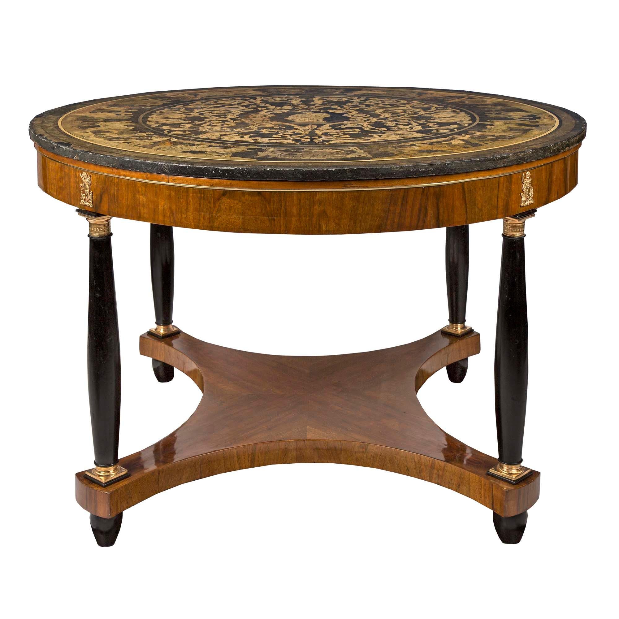 A striking Italian 19th century neo-classical st. walnut and ebonized fruitwood center table, with its original and exceptional Scagliola top. The circular table is raised by ebonized fruitwood feet below the X shaped bottom tier with concave sides.