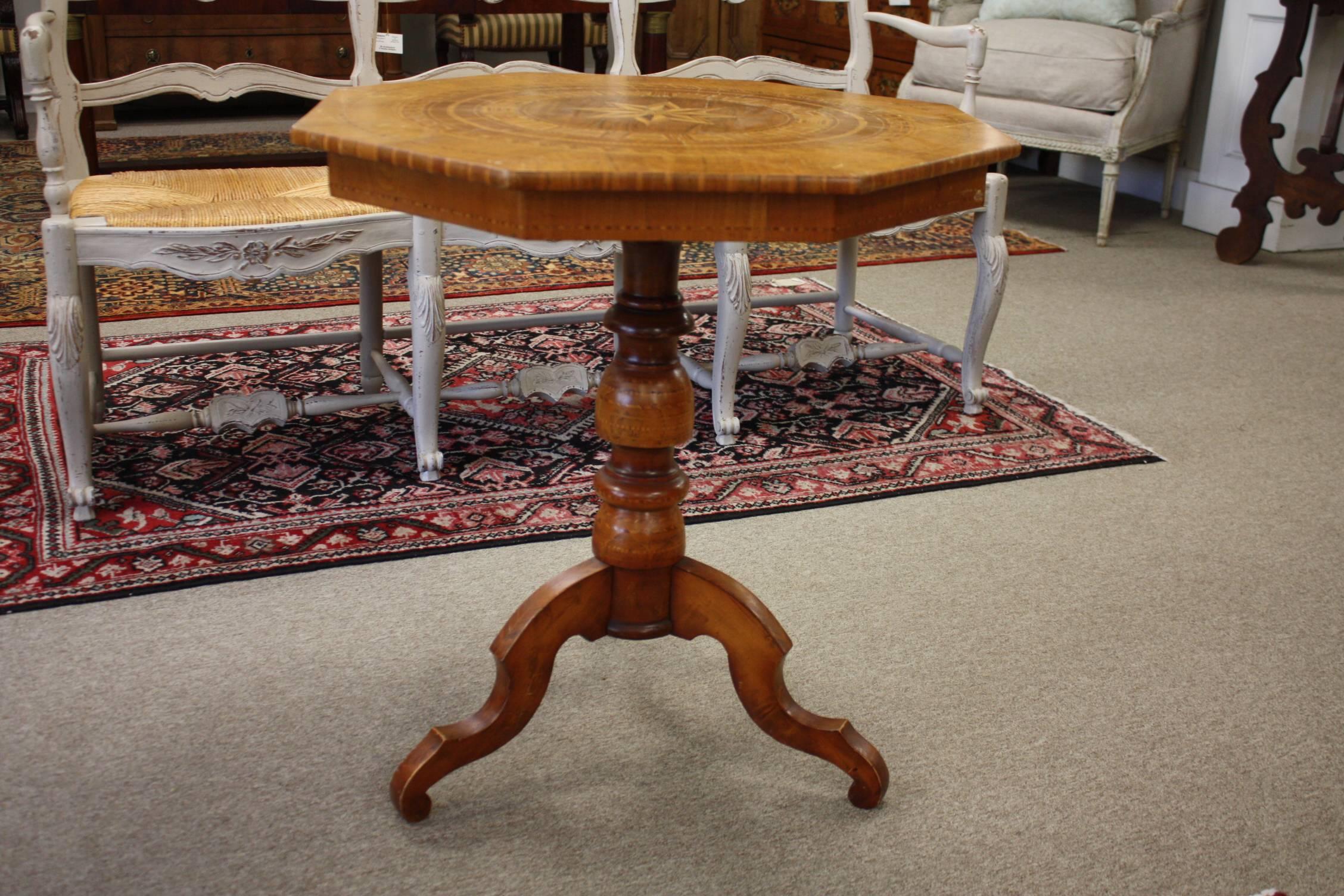An Italian 19th century octagon occasional table. This Italian wood occasional table or side table features an octagon top which rests on a central pedestal column and tripod feet with an inlaid top.  See images for condition and wear.  