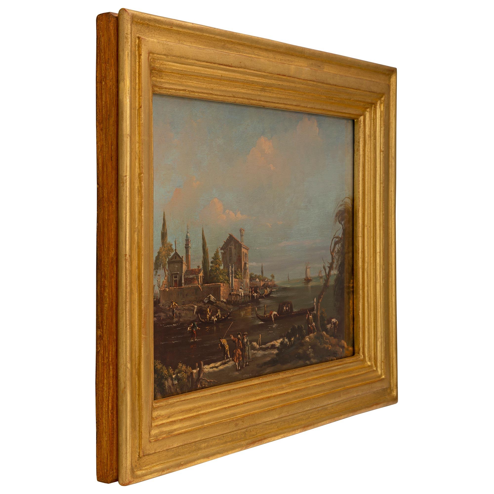 A beautiful Italian 19th century oil on canvas painting. The painting depicts a beautiful Italian scene of personages going about their day with charming boats and a house on the water. The painting is set in an elegant stepped mottled giltwood