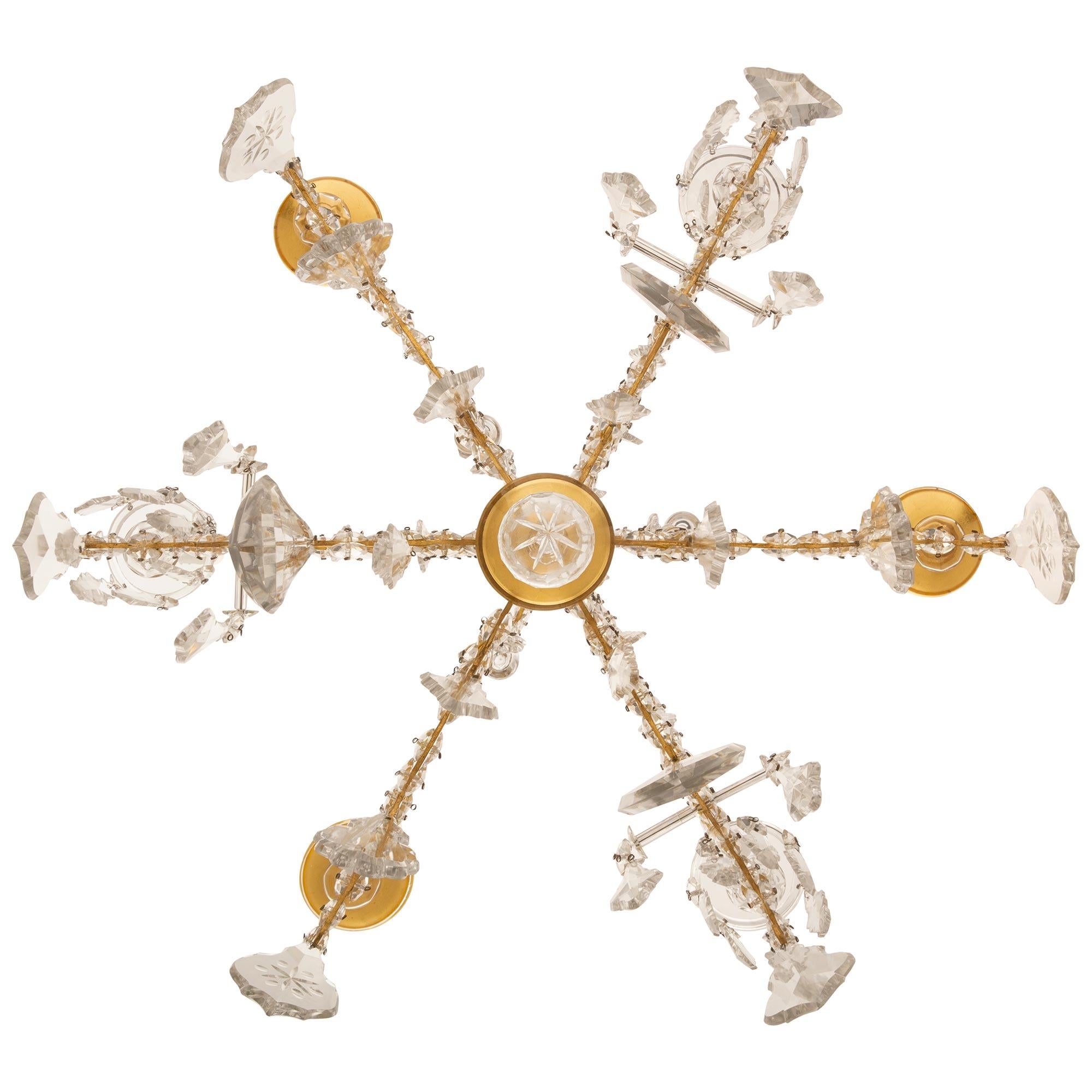 A wonderfully decorative and whimsical Italian 19th century Ormolu, Crystal and Gilt Crystal chandelier. The six arm chandelier has a central gilt dome bottom with a hanging cut crystal ball. Above are six scrolled Ormolu arms which are decorated on