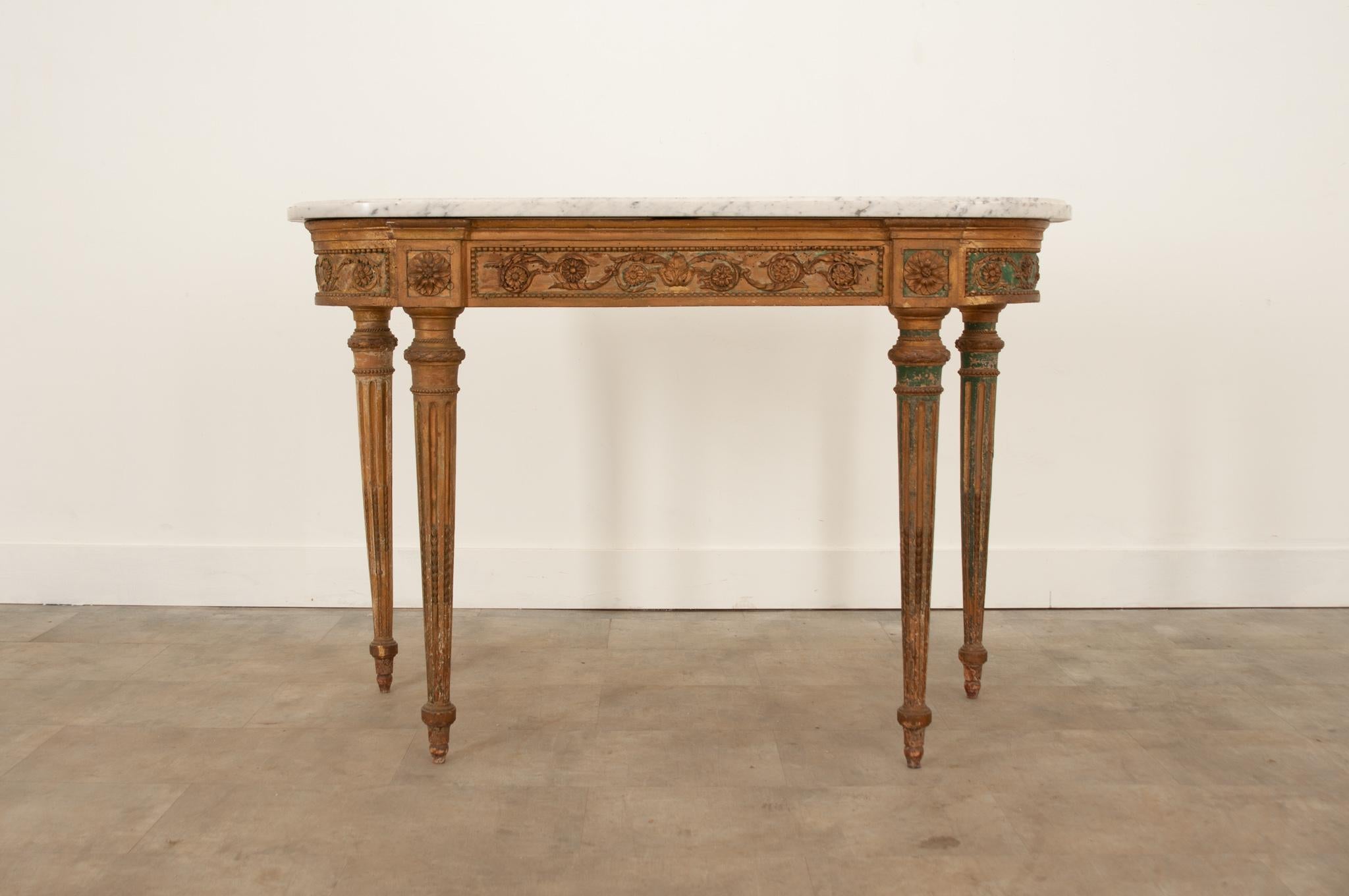 A show stopping painted demilune console table from Italy, circa 1870. The shaped marble top is in great antique condition. The gilt and green paint is worn in just the right way to add an air of old world charm. Rose and acanthus carvings adorn the