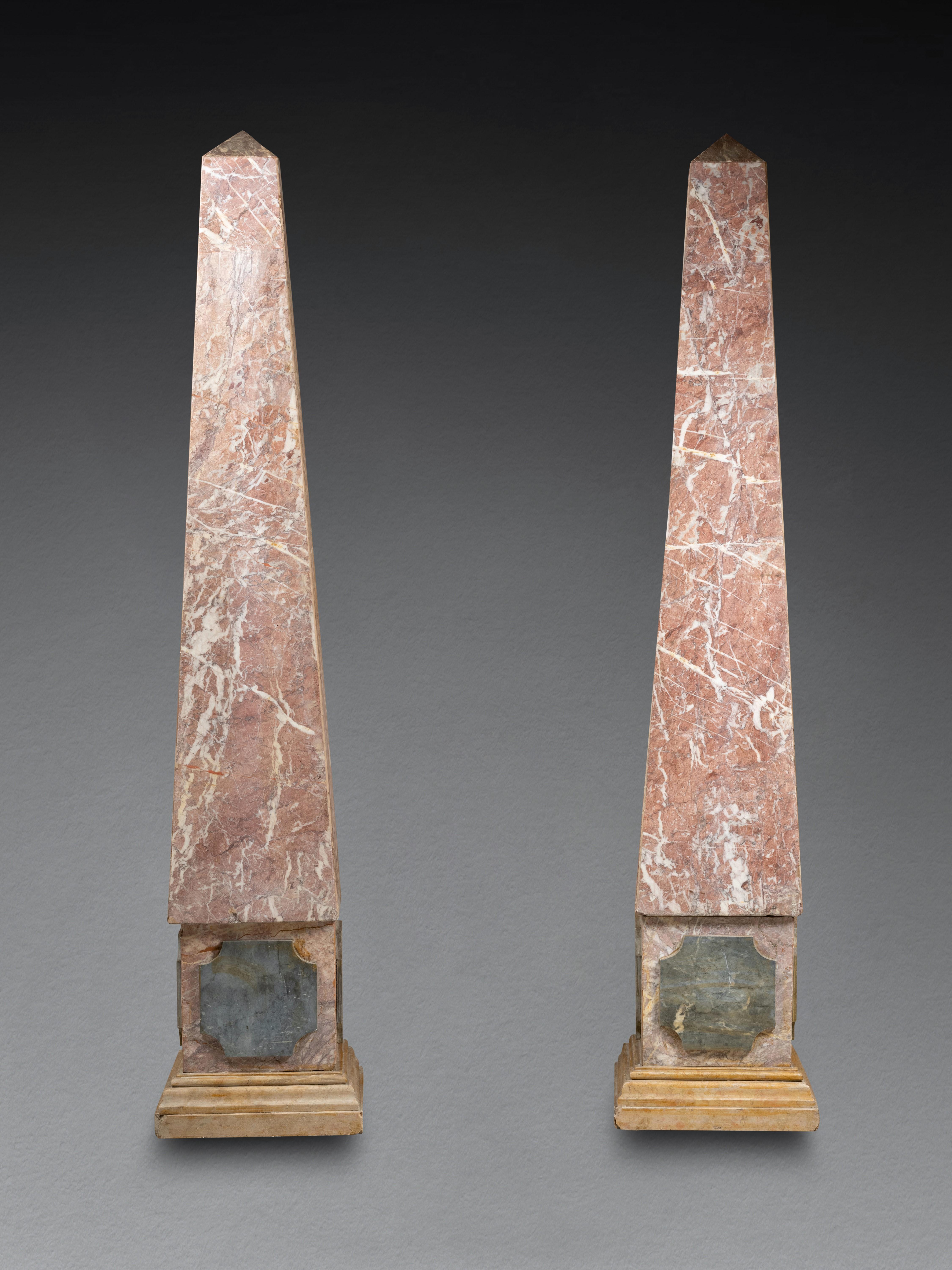 Monumental pair of obelisks veneered with following marbles:  pink marble of the Pyrenees, blue Turquin and yellow of Siena.
A very decorative pair of tall obelisks that would look great in any interior.
The obelisks are hollow and made in two parts