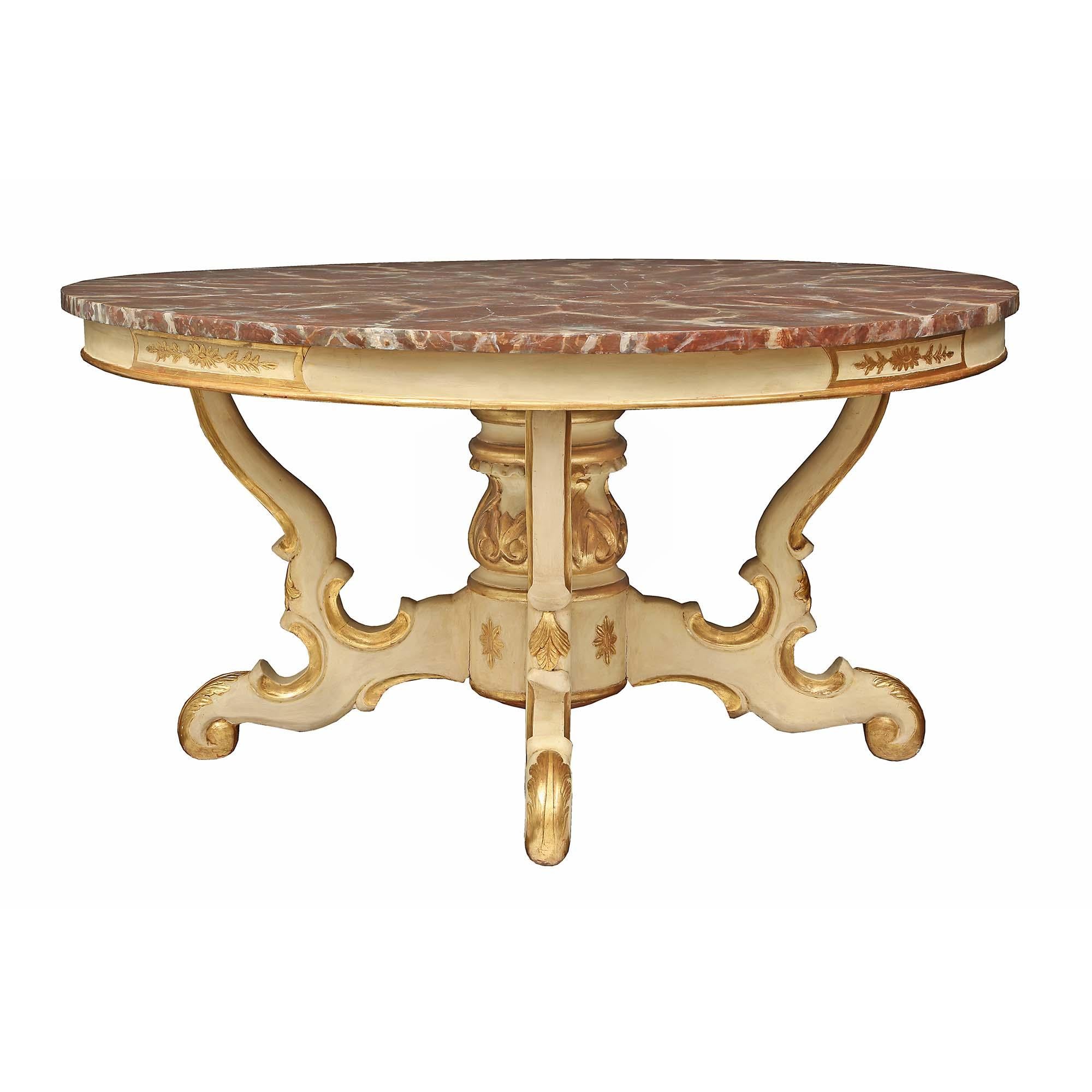 An extremely decorative and large scale Italian 19th century patinated and gilt center table. The table is raised by four elegant scrolled patinated legs with fine gilt trim and rosettes. The central pedestal support is decorated with large gilt