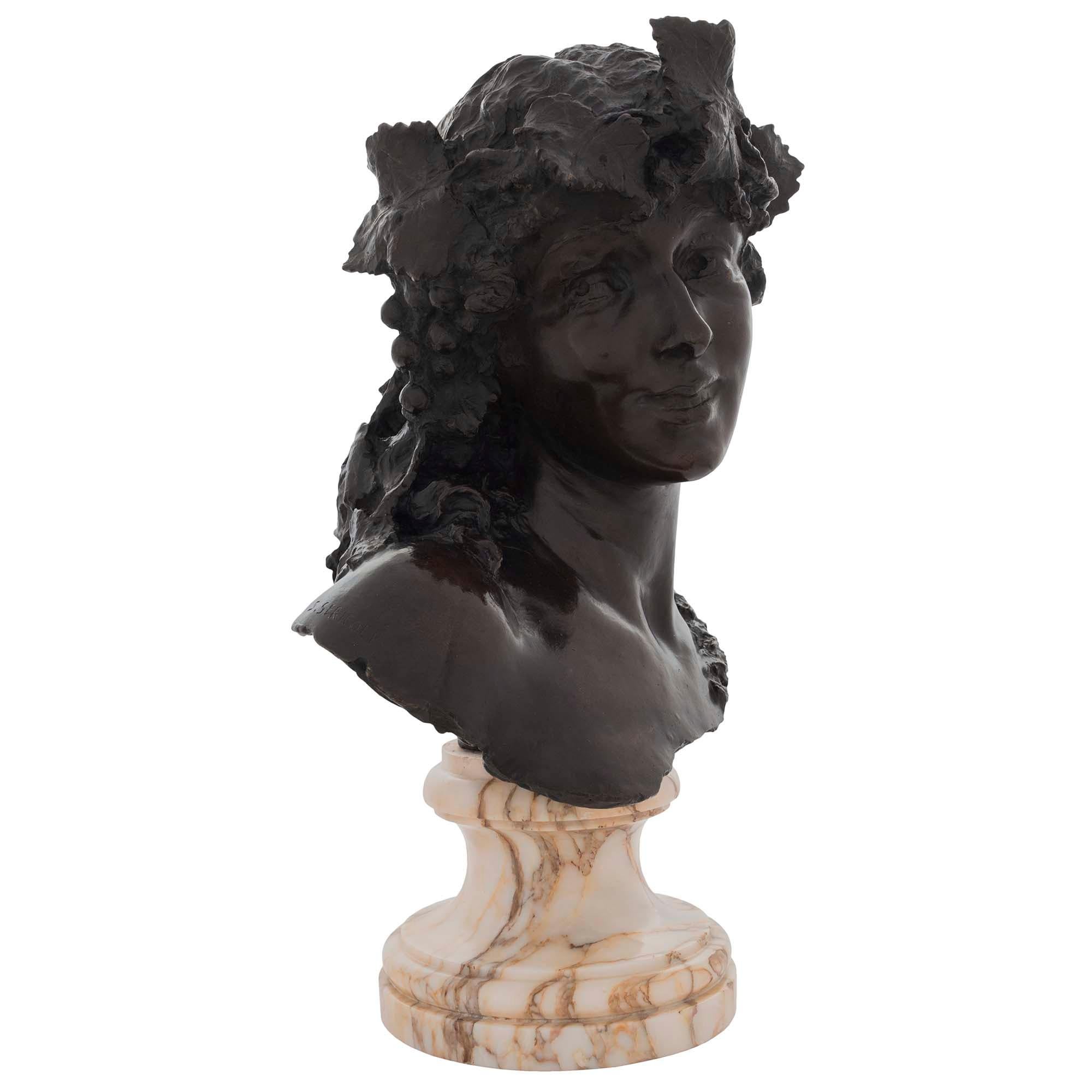 An elegant Italian 19th century patinated bronze of a young woman, signed by Silvio Sbricoli. The bust is raised by a circular mottled Pink Lez Breccia marble socle. The lady gazes towards the left with a wonderful facial expression and a grape