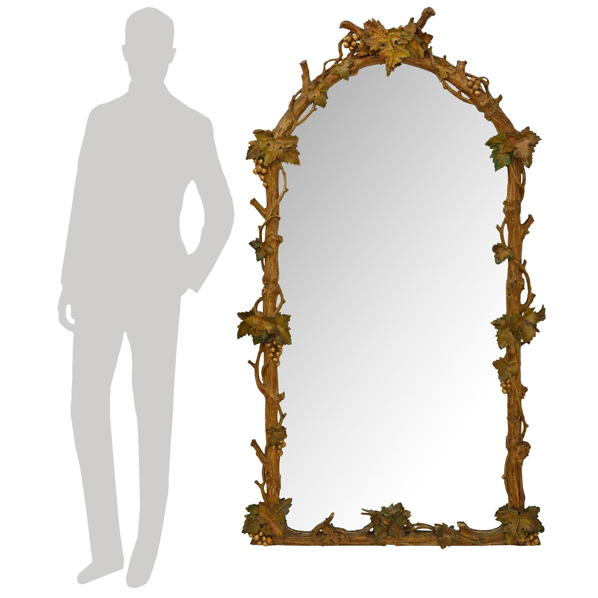 Miroir polychrome, en bois patiné et doré, de style italien du 19e siècle, merveilleusement décoratif. Ce miroir tout à fait unique, avec une couronne supérieure incurvée, est richement décoré de charmants motifs en faux bois. Le cadre présente une