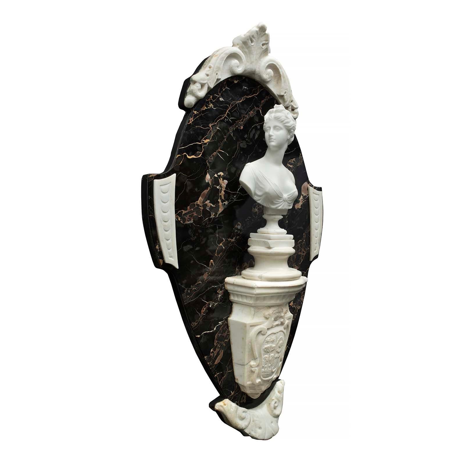 A sensational and large scale Italian 19th century Portoro and white Carrara marble wall crest. The crest with an oblong design has a bottom acanthus leaf below the carved family crest. Above the crest is a column supporting an elegant bust of Diana
