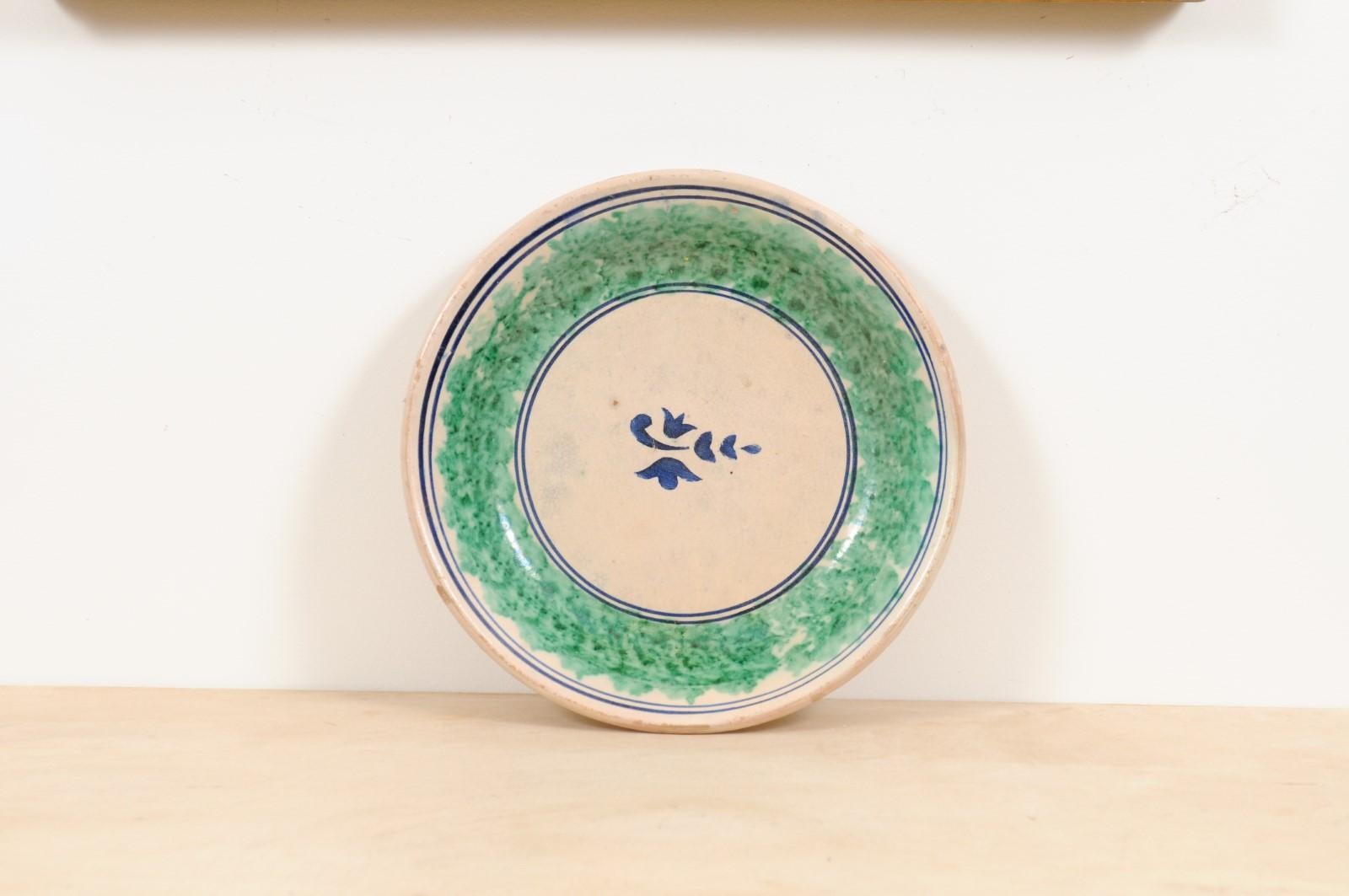 An Italian pottery platter from the 19th century, with stylized foliage motif, green and blue tones. Created in Northern Italy during the 19th century, this circular pottery platter features navy blue and green tones alternating on a neutral ground.