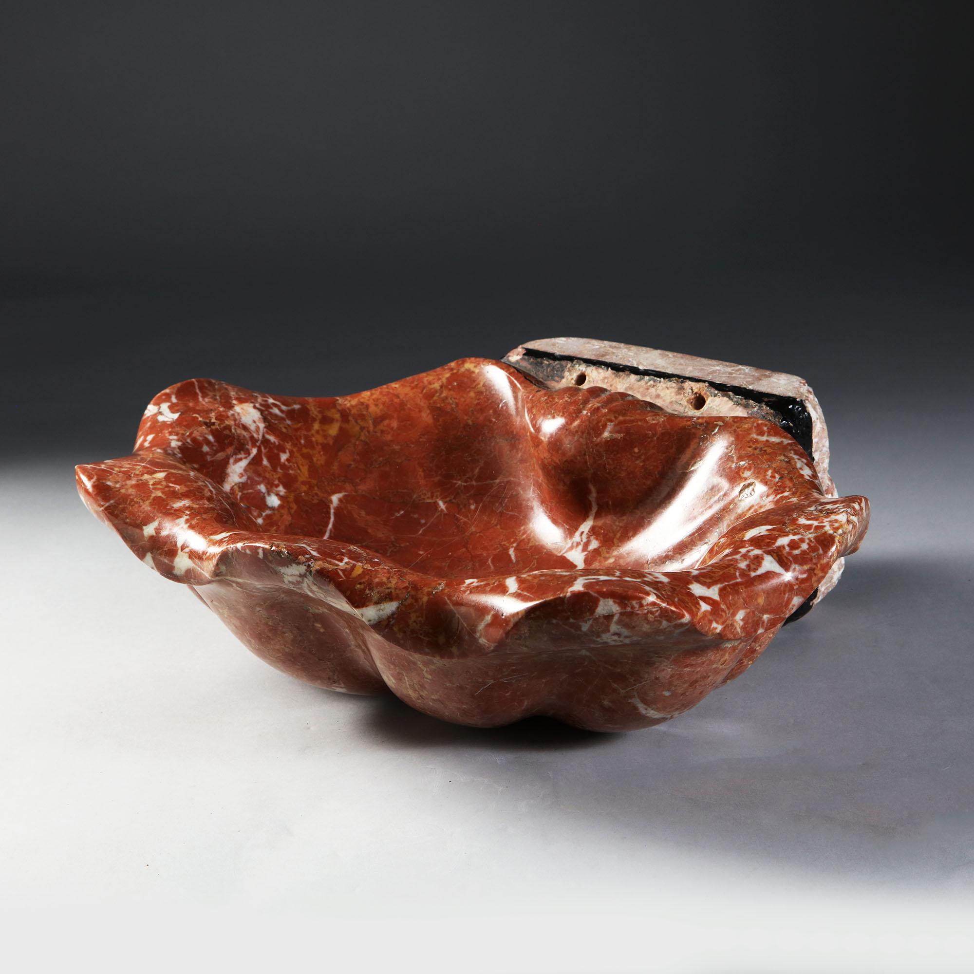 A fine 19th century red marble basin in the form of a scallop shell.

 