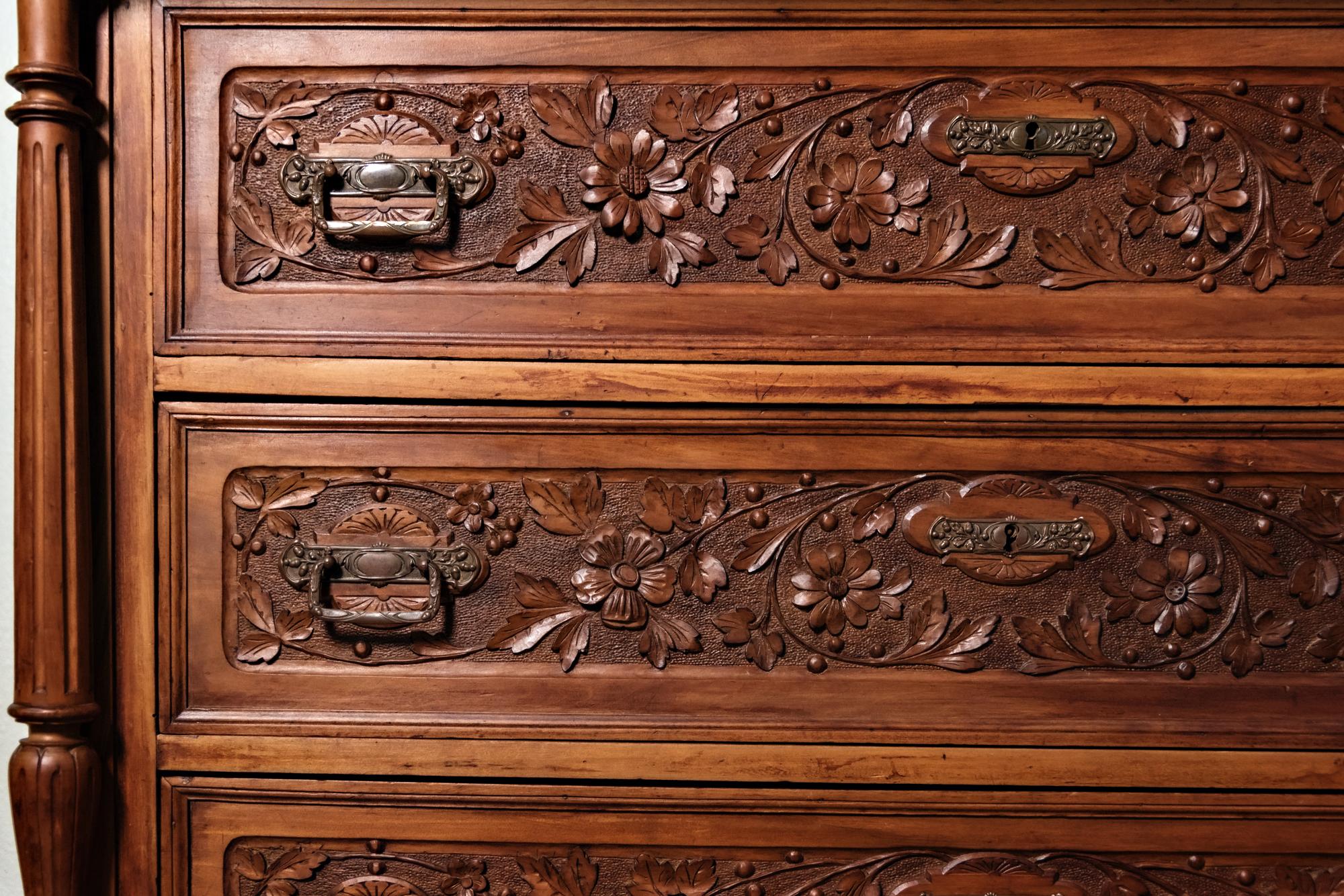 19th century Italian Renaissance walnut commode represents the essence of the style with elaborately carved bas relief and full relief naturalistic leaf and floral motifs across the entire facade. It features bun feet and beautifully carved columns
