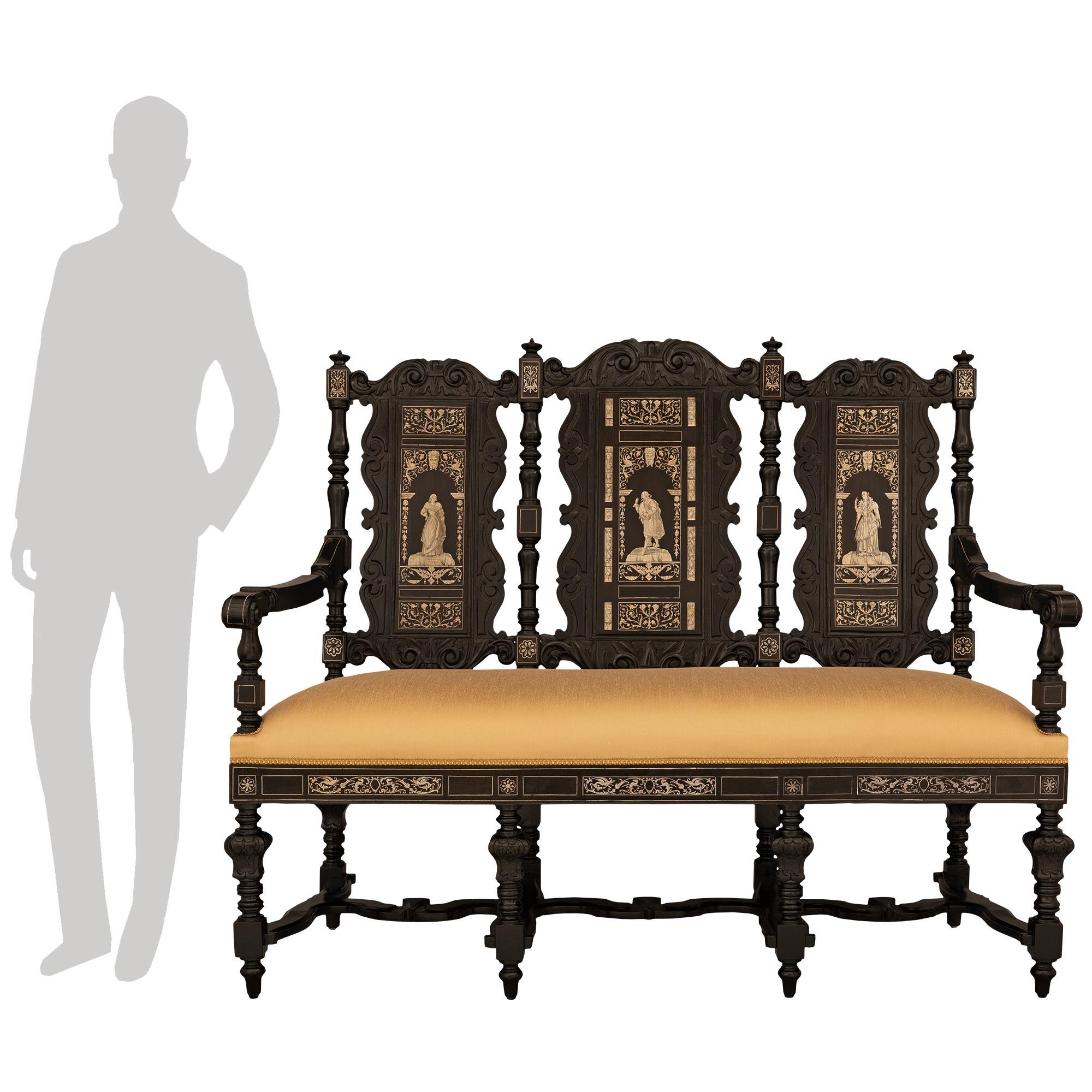 Una bella e decorativa poltrona italiana del XIX secolo in stile rinascimentale, intarsiata in ebano e osso. Questa splendida poltrona è sollevata da otto gambe screziate e sorretta da piedi a forma di topie. Al di sopra della tripla 