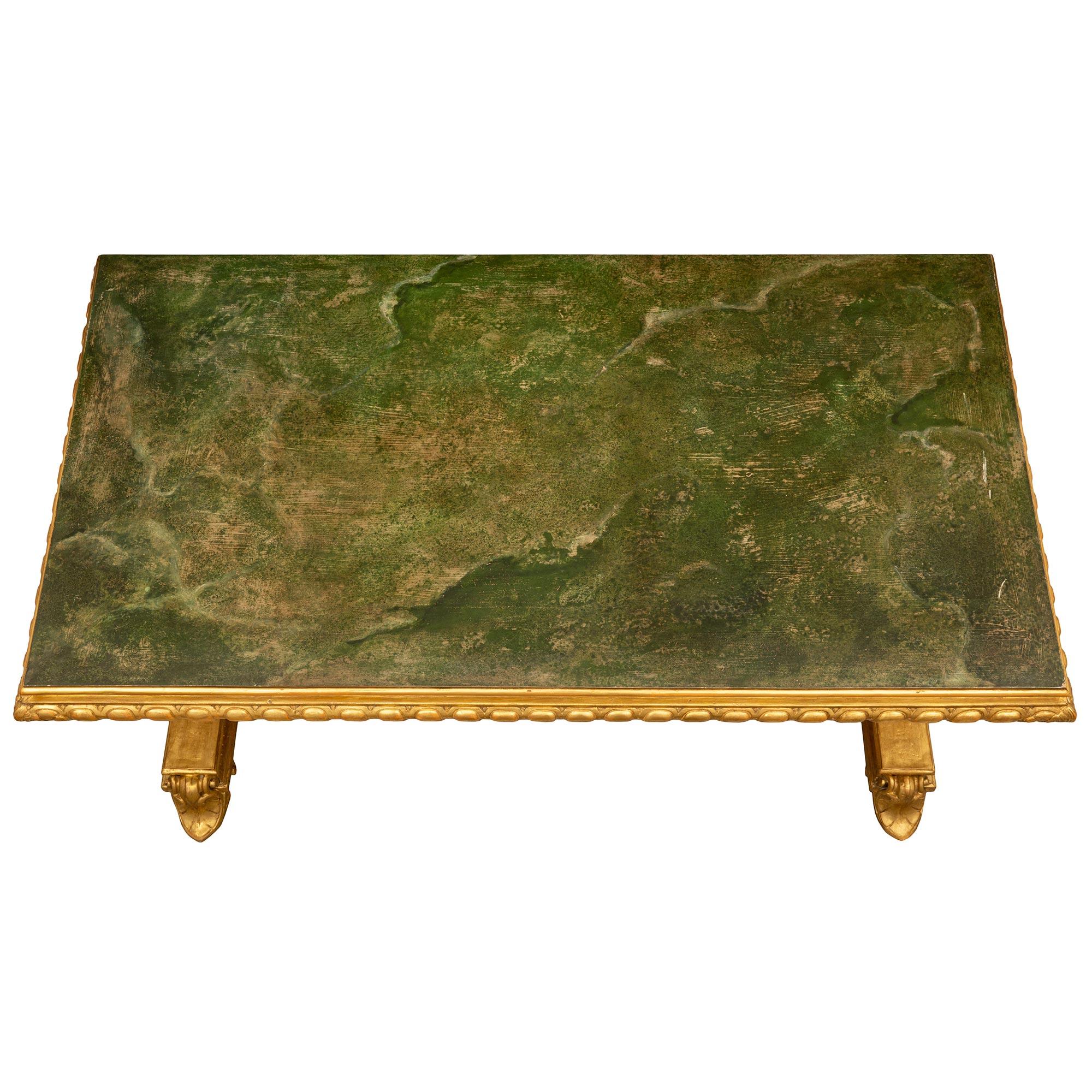 An impressive and most handsome Italian 19th century Renaissance st. giltwood and faux painted marble center table. The rectangular table is raised by beautiful palmette designed feet below elegant mottled fluted plinths which extend along the