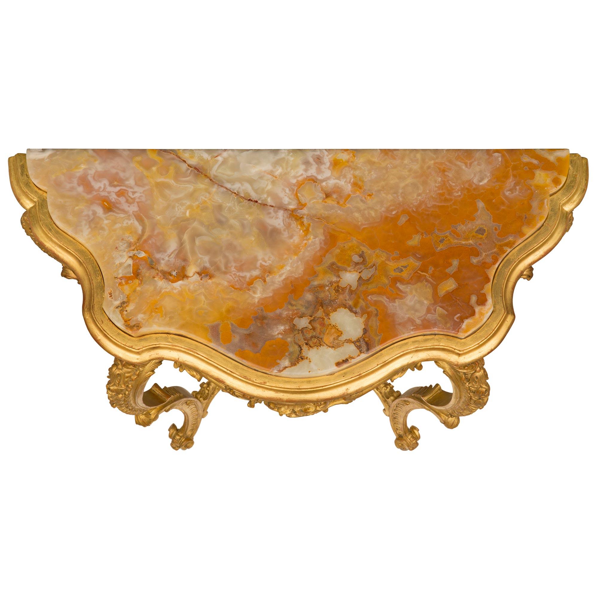 Eine außergewöhnliche italienische Rokoko-Konsole aus vergoldetem Holz und Onyx aus dem 19. Die freistehende Konsole steht auf eleganten, spitz zulaufenden Cabriole-Beinen mit topieförmigen Füßen unter schönen, verschnörkelten Blattwerken und