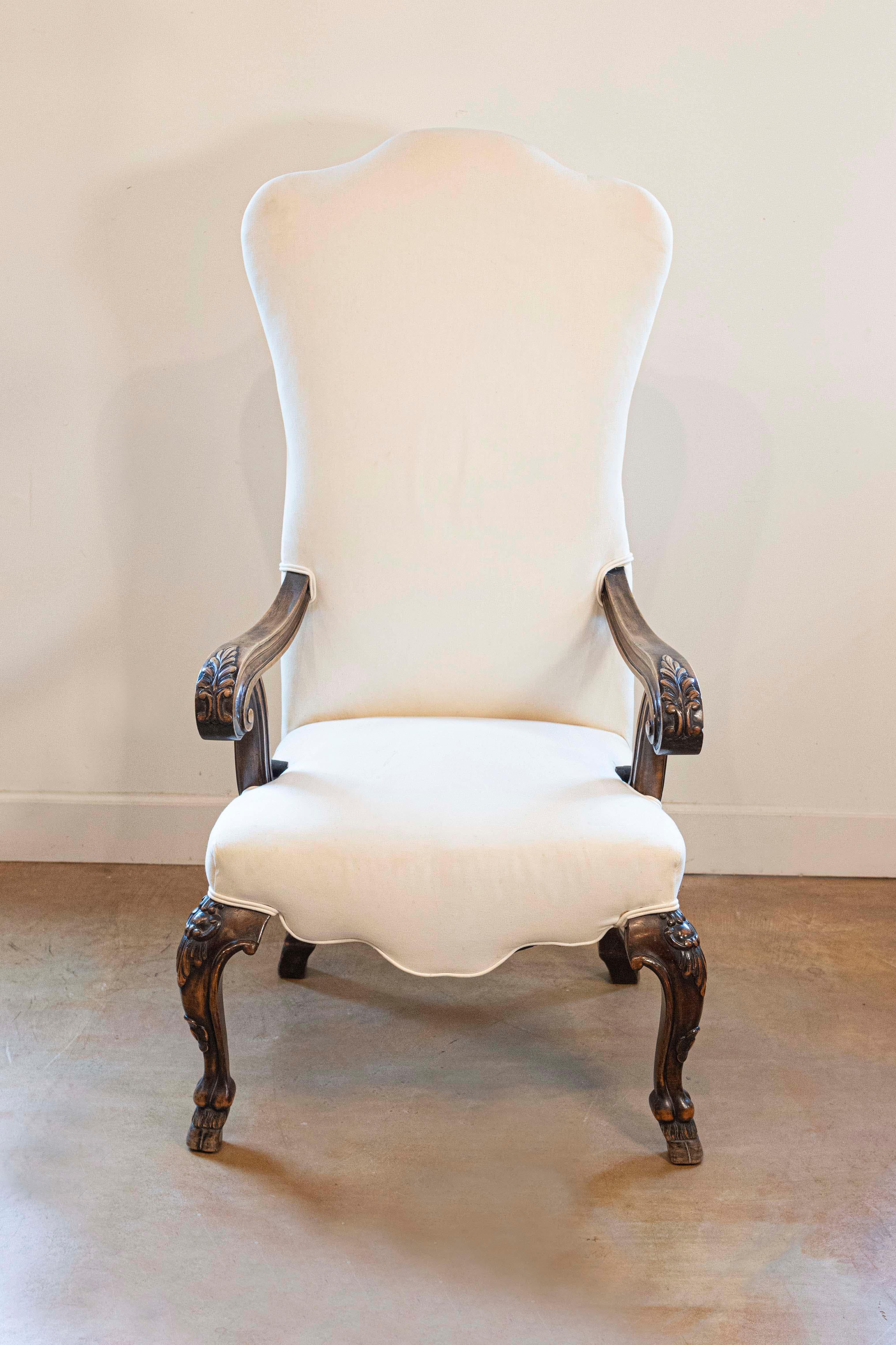 Poltrona in noce con schienale alto in stile rococò italiano del XIX secolo con braccioli aperti a voluta, gambe cabriole su piedi a zoccolo e imbottitura. Questa poltrona in stile rococò italiano presenta un alto schienale a cammello, rivestito,