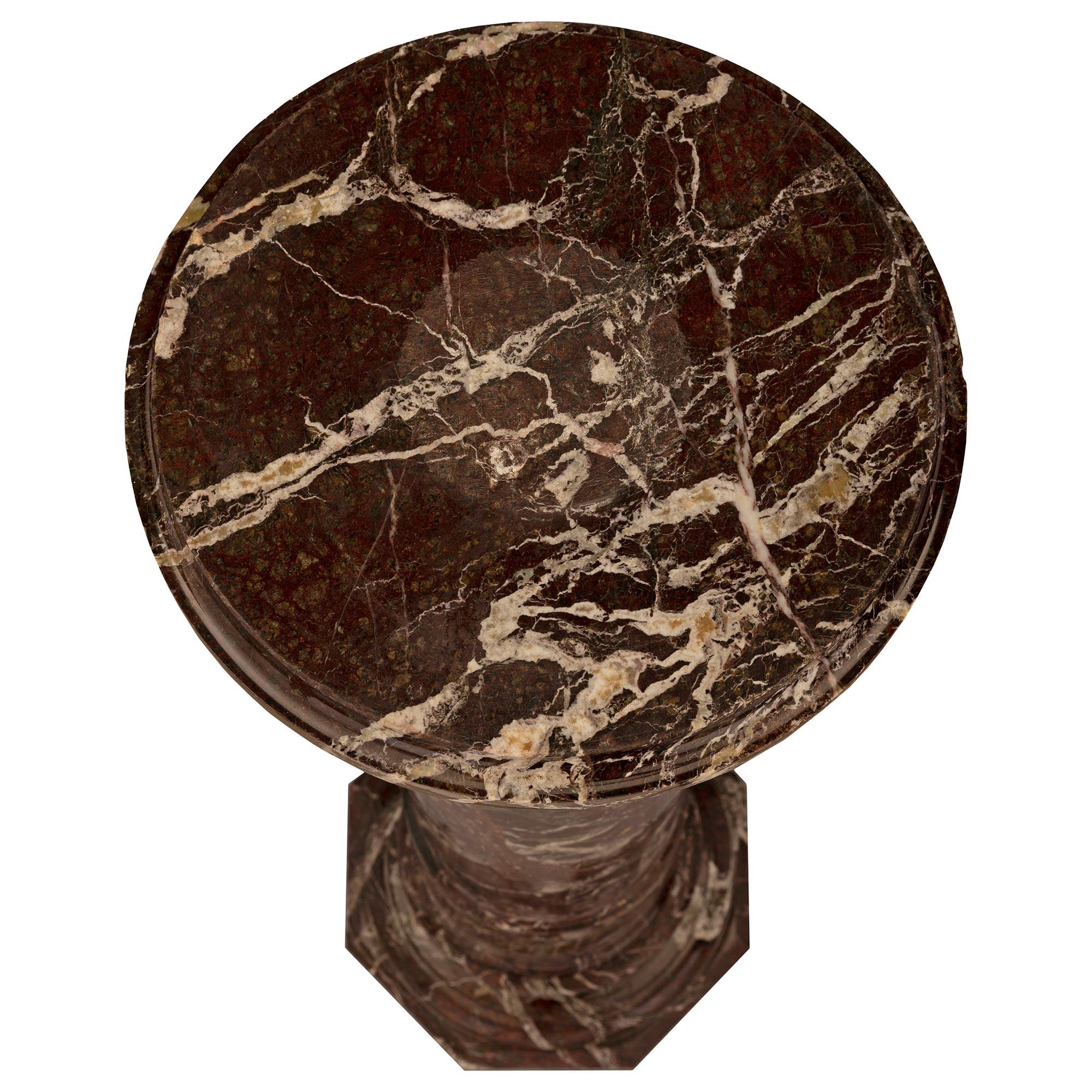 Magnifique colonne italienne du XIXe siècle en marbre Rosso Levanto. Le piédestal est surélevé par une base octogonale avec un support de piédestal en forme de socle à fines marbrures. Le support central circulaire présente un fin filet enveloppant,