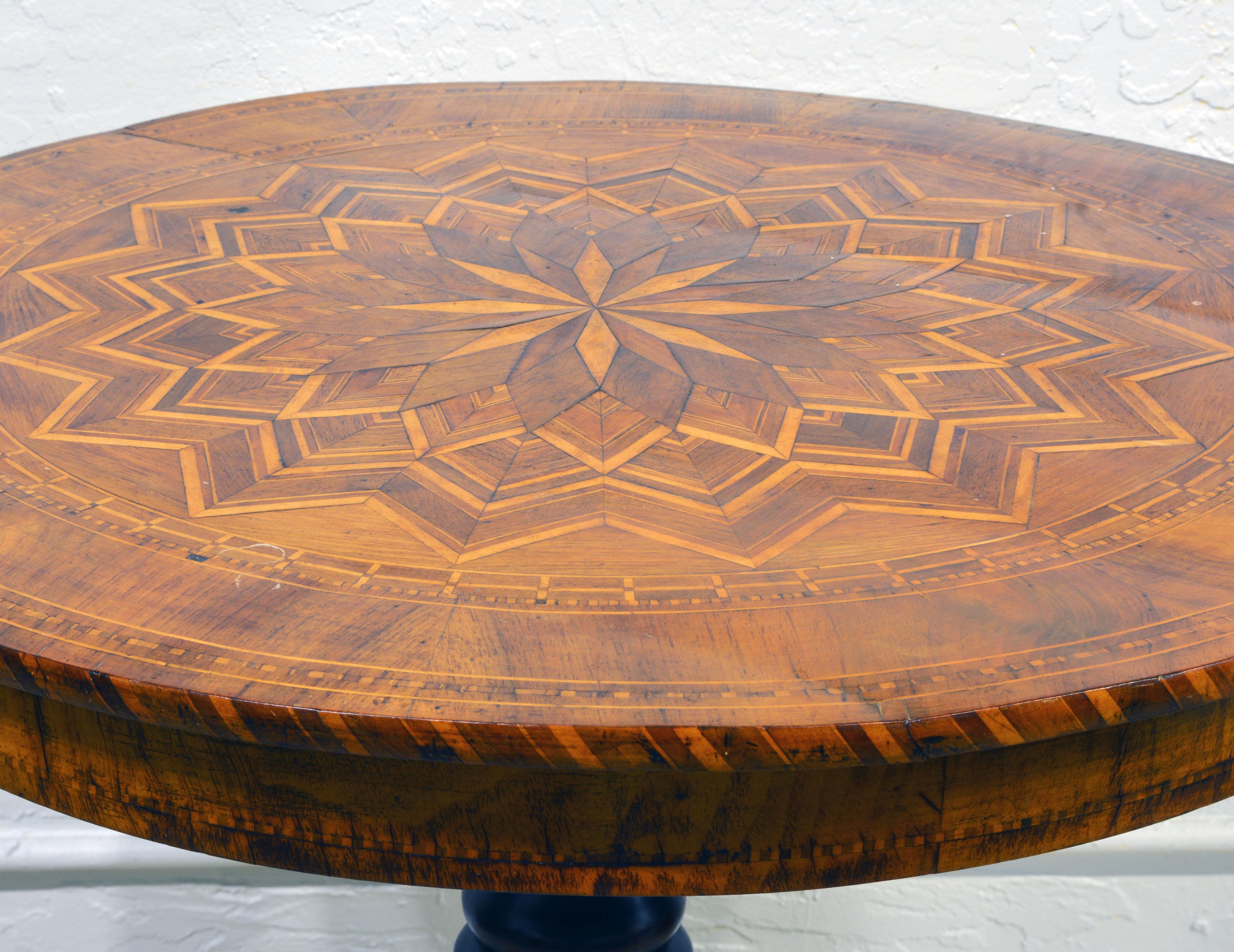 This table features a fine star-shaped parquetry inlaid top resting on a turned and inlaid center column ending in shaped tripod feet. The term Sorrento table refers to the type of inlay and parquetry for which especially the craftsmen in an around