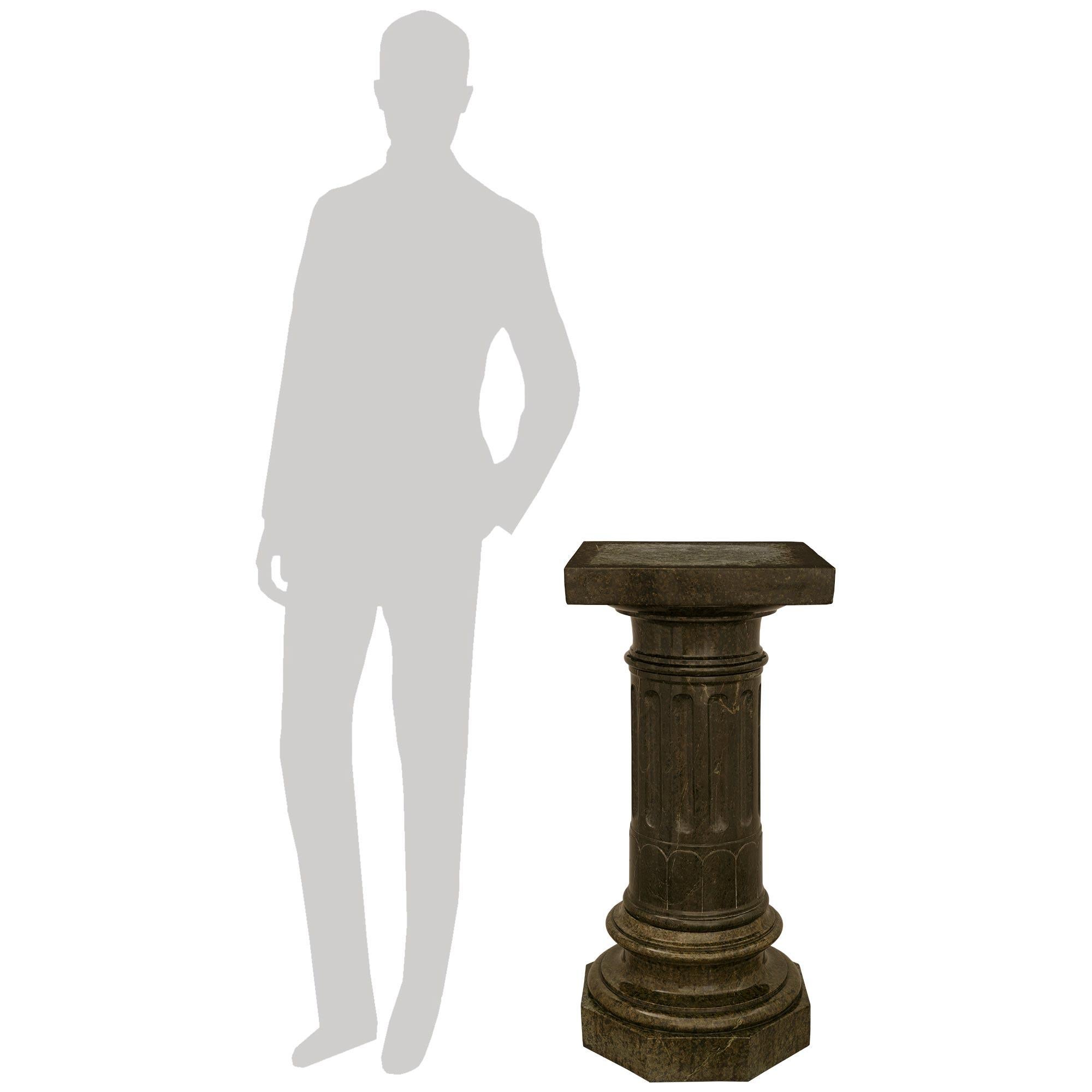 A handsome and most impressive Italian 19th century Serpentine marble pedestal. This large scale pedestal is raised by an octagonal base with a socle shaped circular plinth above. The central column is richly decorated by wonderful wrap around