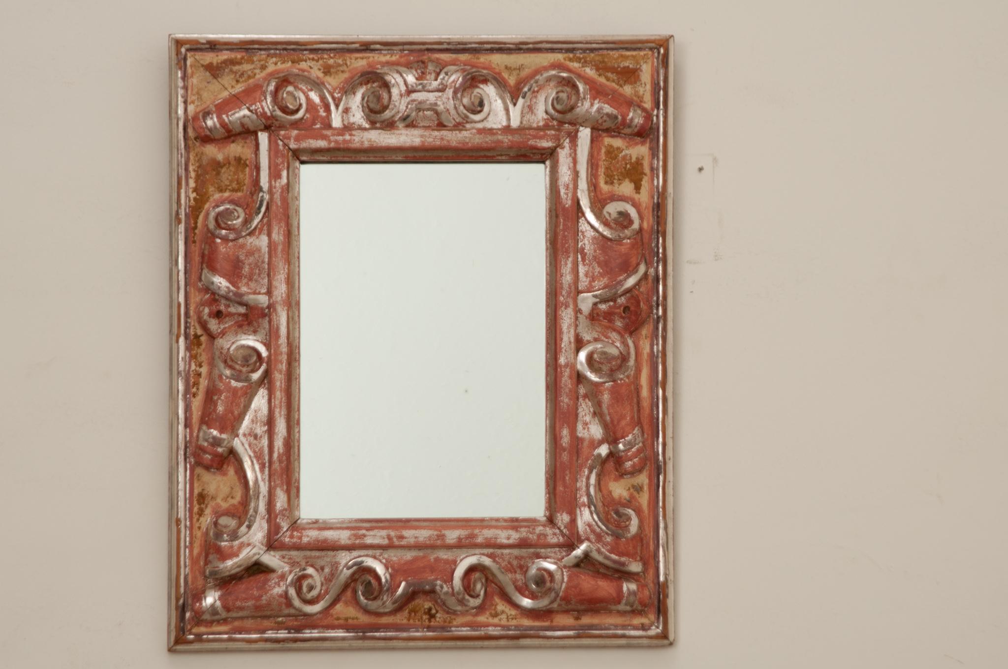 A lovely and unique Italian giltwood carved mirror made in the 19th Century. This silver gilded rectangular mirror is eye-catching with richly carved scrolls decorating the frame. The surround is beautifully colored by age, showing the remaining