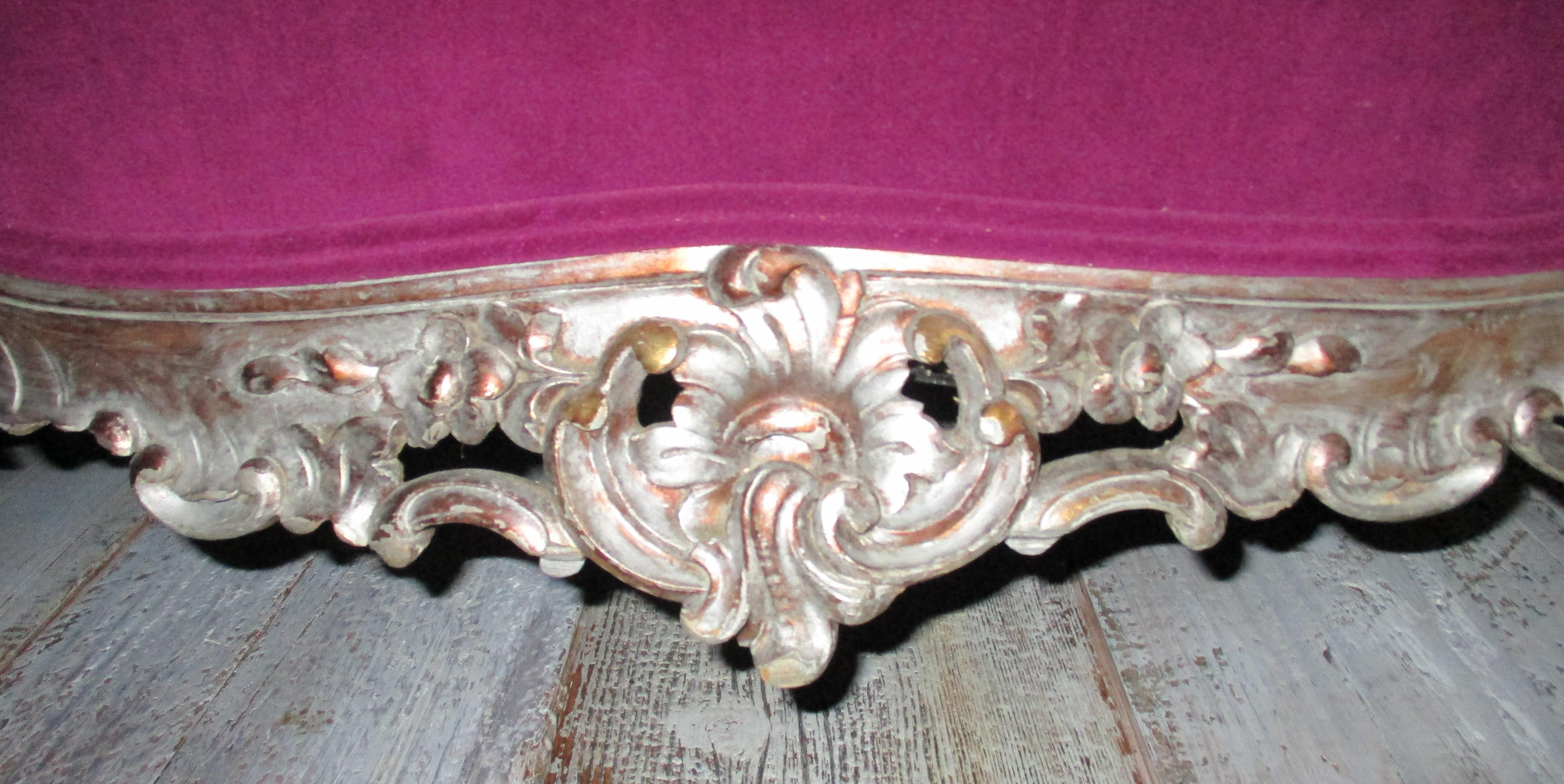 Beautiful from every angle, this gorgeous Italian Baroque sofa has been recovered in Orchid velvet with a large feather stuffed cushion and single piping trim. The settee features fine hand carved details of acanthus leaves and flowers along the