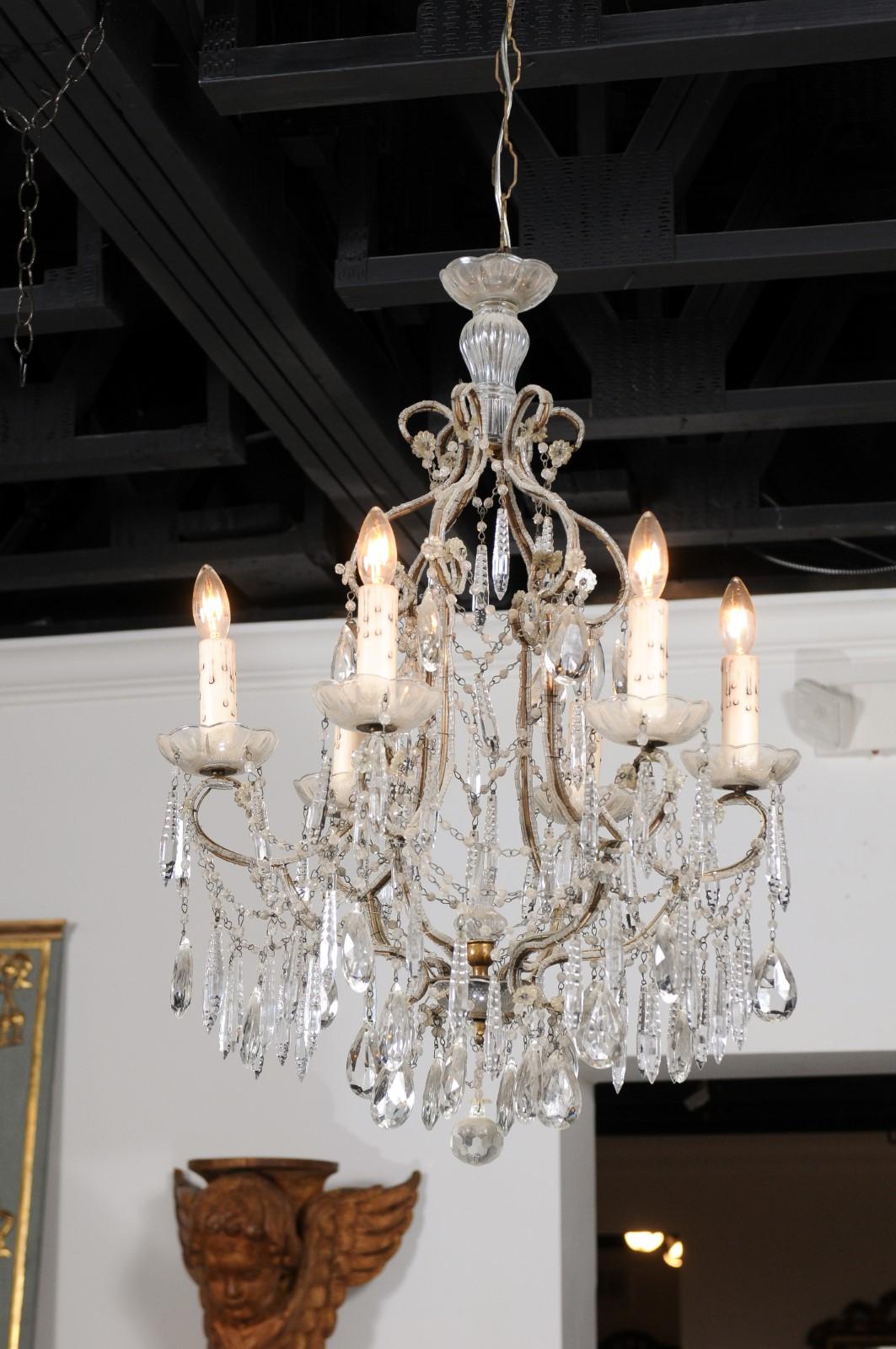An Italian six-light crystal chandelier from the 19th century, with beaded scrolled arms, spear crystals and etched glass bobèches. Created in Italy during the 19th century, this crystal chandelier features a gilt armature delicately accented with