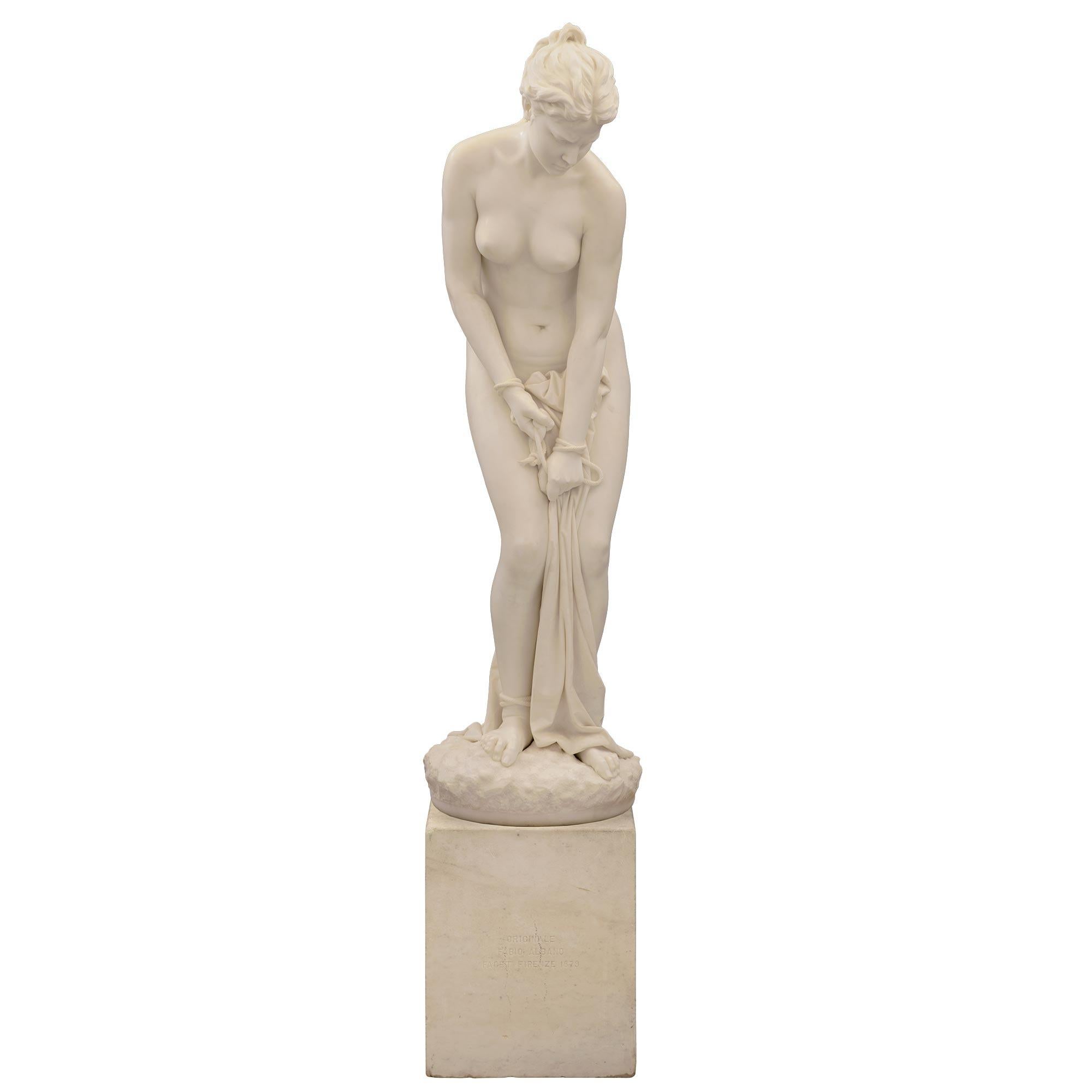 A stunning and extremely high quality Italian 19th century solid white Carrara marble statue of a woman with bound hands and feet. The statue, with a very unique subject matter, is raised on its original square base with 