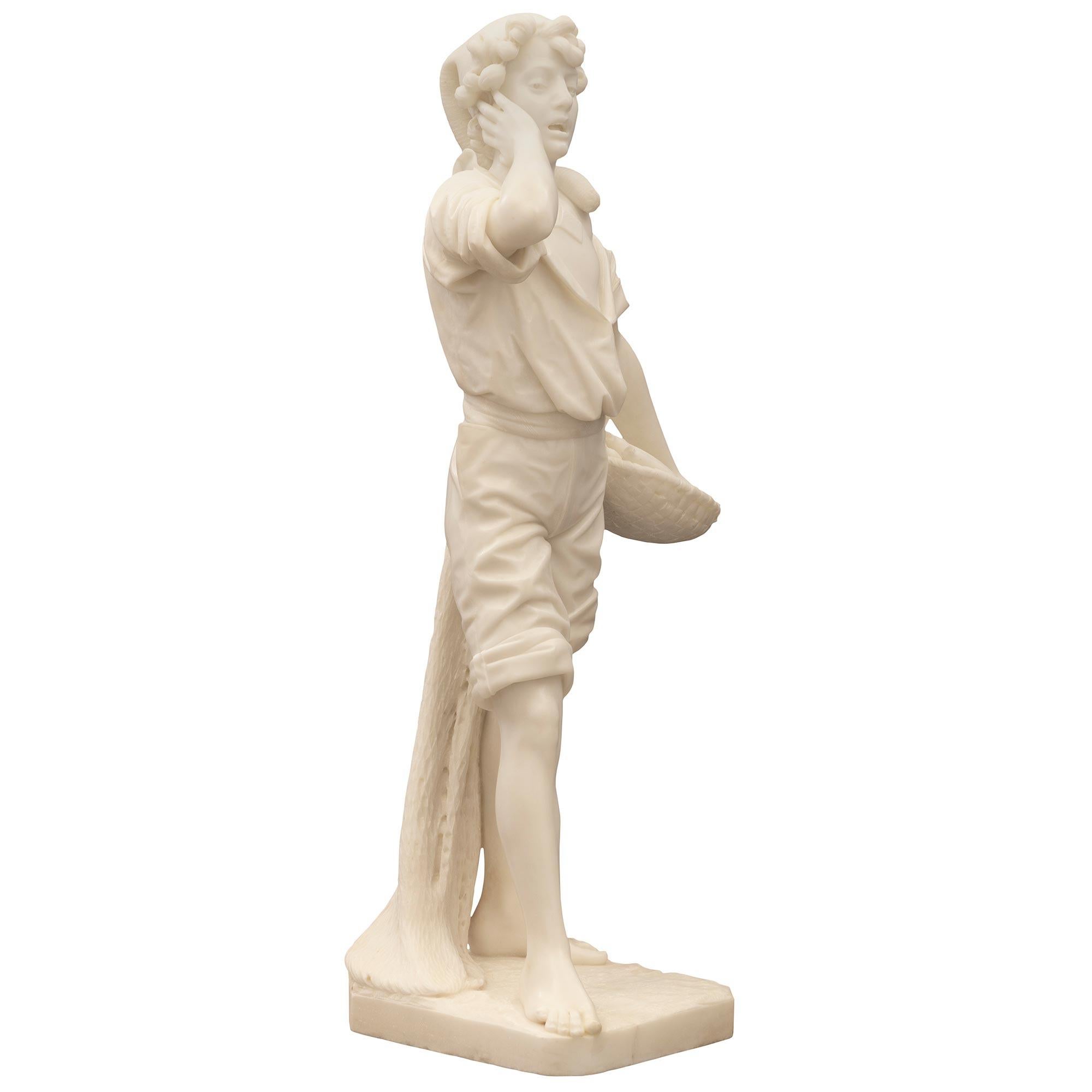 A stunning and extremely high quality Italian 19th century solid white Carrara marble statue of a young fisherman. The statue is raised by a square base with cut corners and a fine ground like design. Above is the charming young boy dressed in