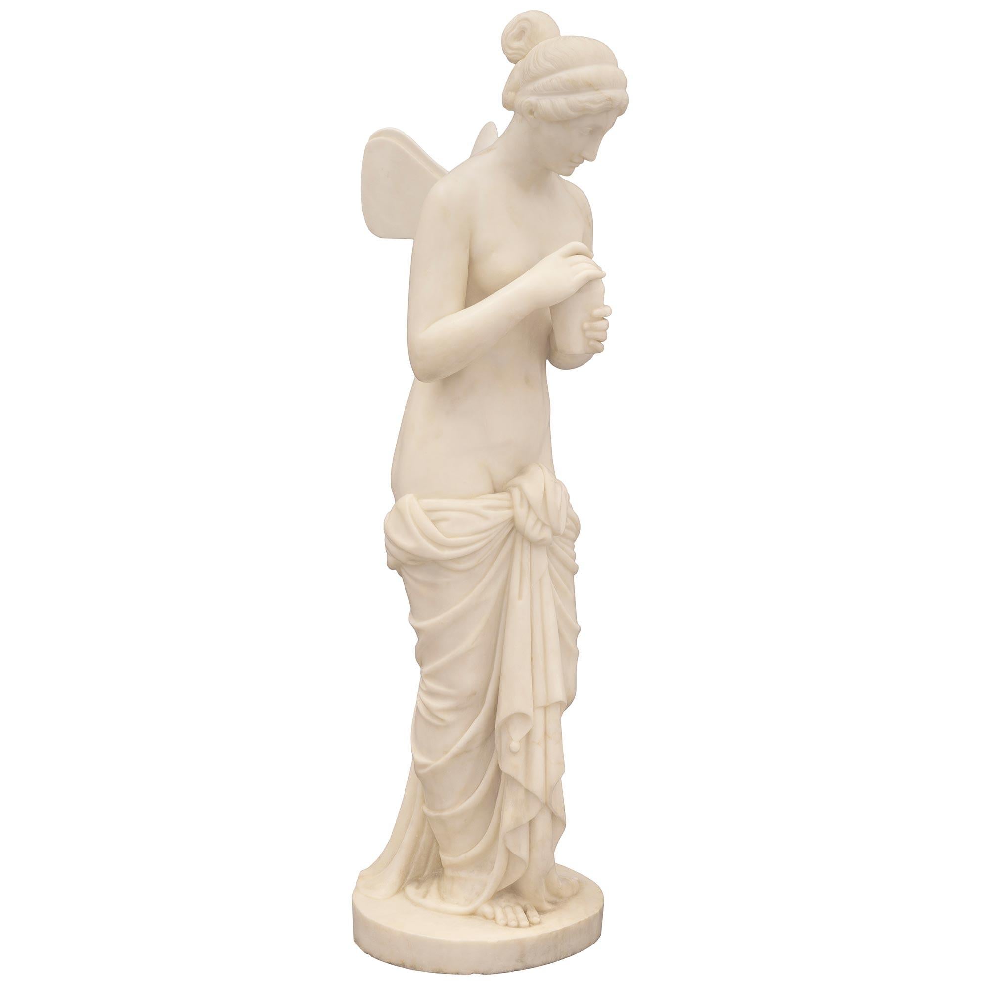 A beautiful and very high quality Italian 19th century solid white Carrara marble statue of Psyche. The statue is raised by a circular base where the beautiful Psyche is standing. She is draped in a wonderfully executed and intricately detailed
