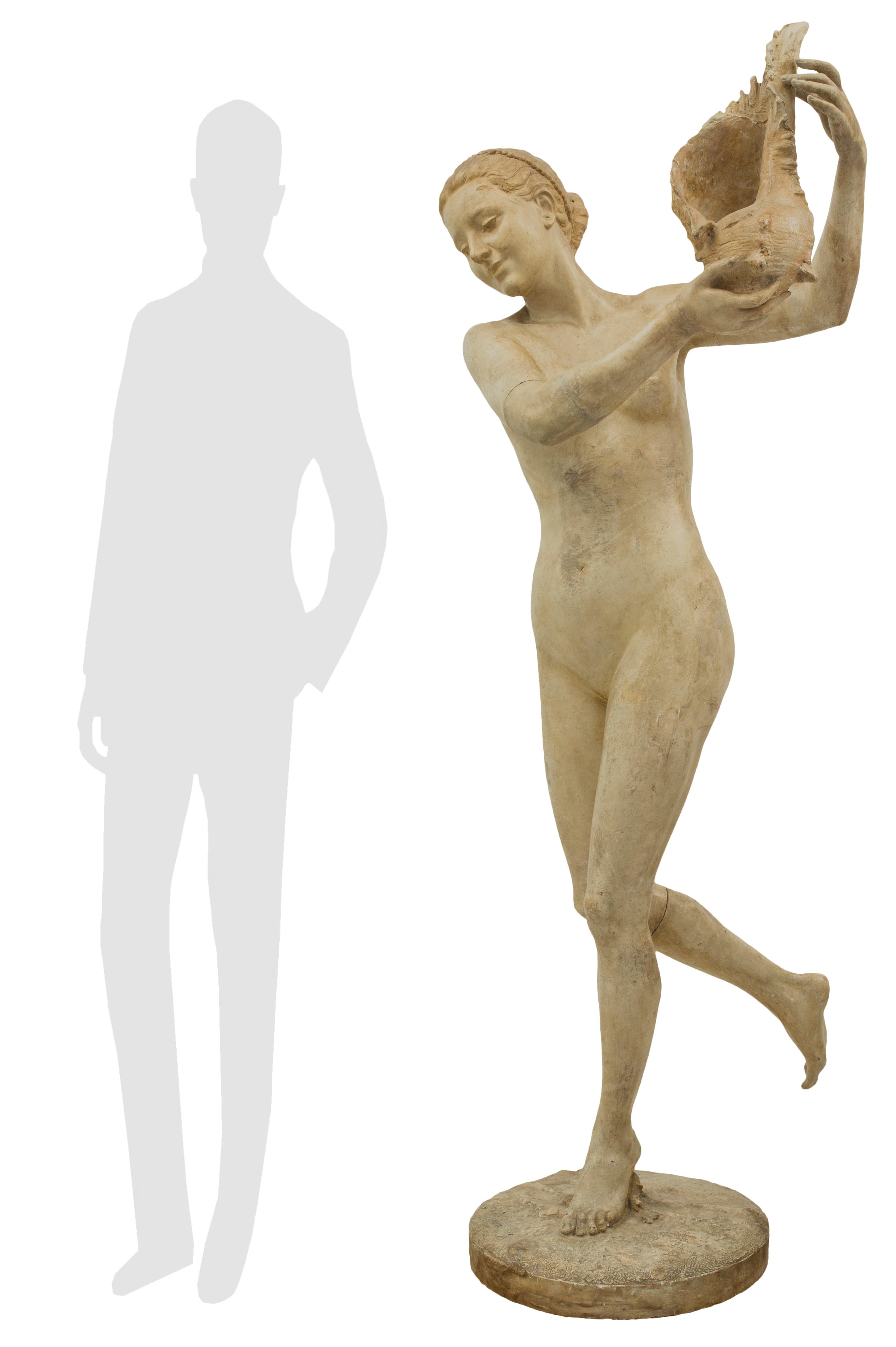 Charmante statue italienne en plâtre du XIXe siècle représentant une belle jeune femme tenant un grand coquillage, signée Gabrieli. La statue est surélevée par une base circulaire au design semblable à celui d'un terrain et la dame souriante,