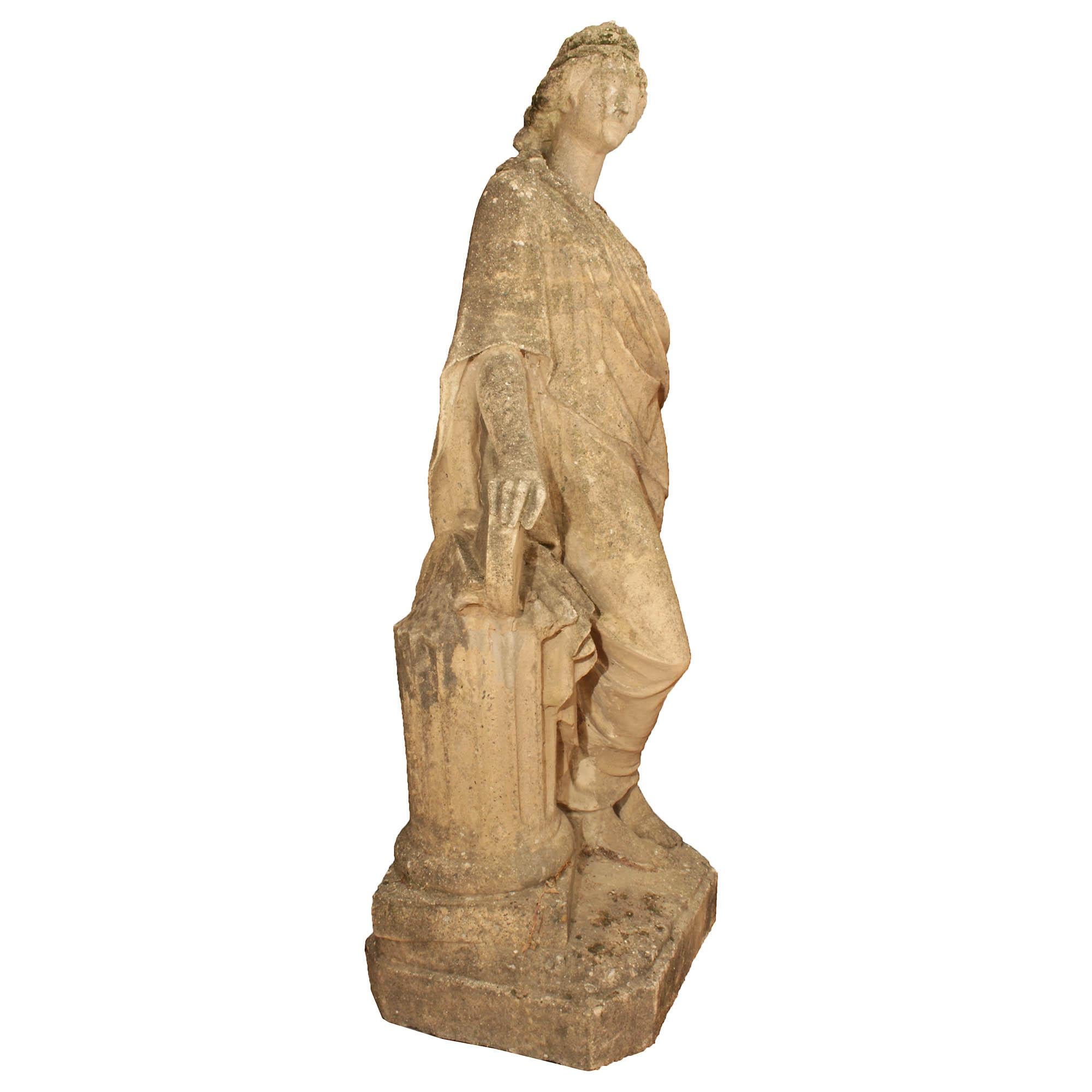 A lovely Italian 19th century stone statue. The Classic female figure is raised on a square stone base with cut corners. She is leaning on a fluted column with her legs crossed. The figural is adorned in classical dress with her hair up, dressed