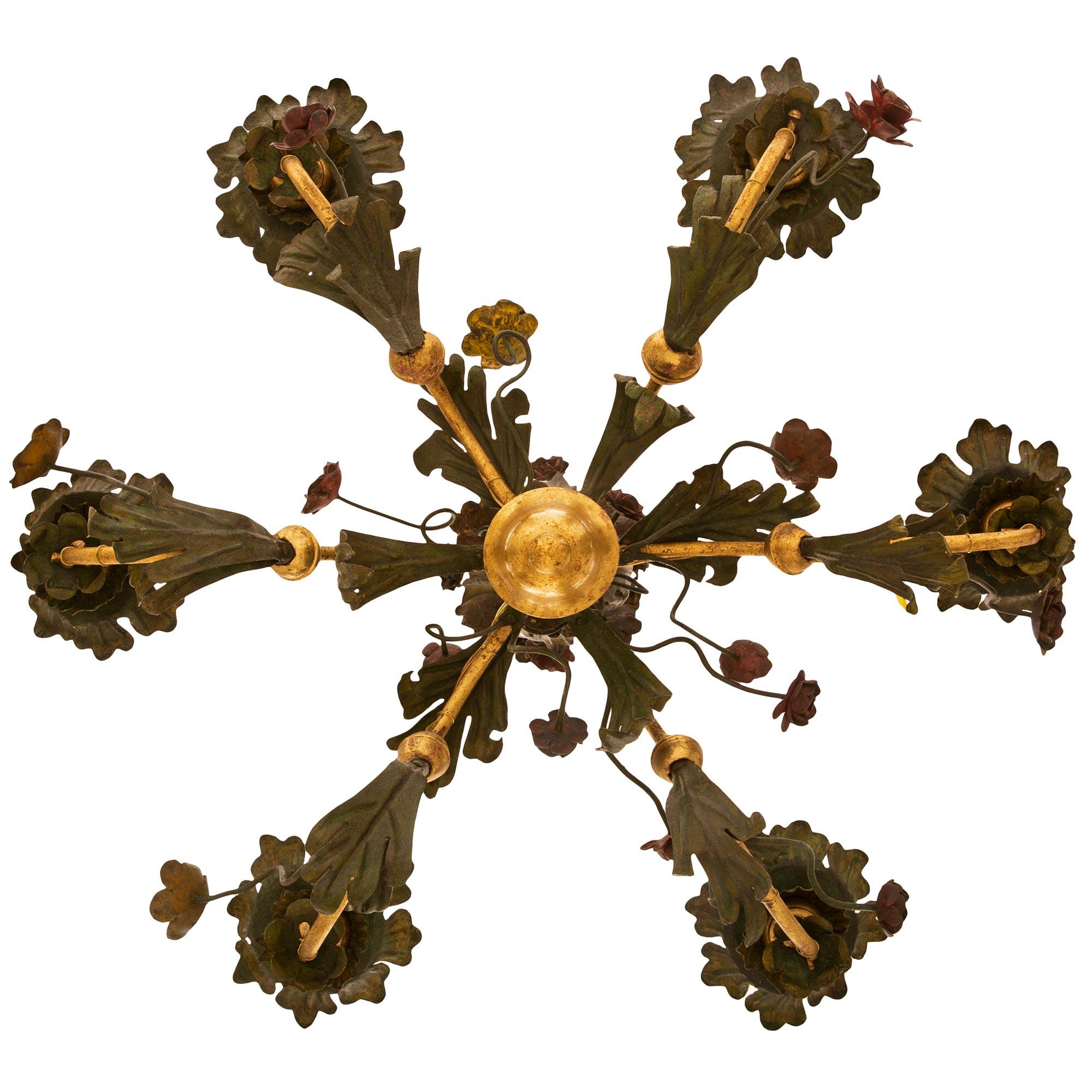 An Italian 19th century Tuscan st. patinated and gilt iron chandelier. This whimsical six arm chandelier is centered by an inverted bell-shaped Giltwood final leading up to the six scrolled arms adorned with large patinated iron acanthus leaves and