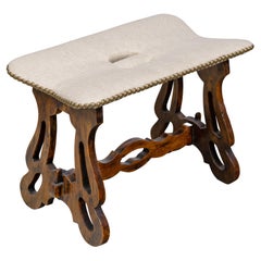 Poggiapiedi italiano del XIX secolo in noce imbottito con base intagliata
